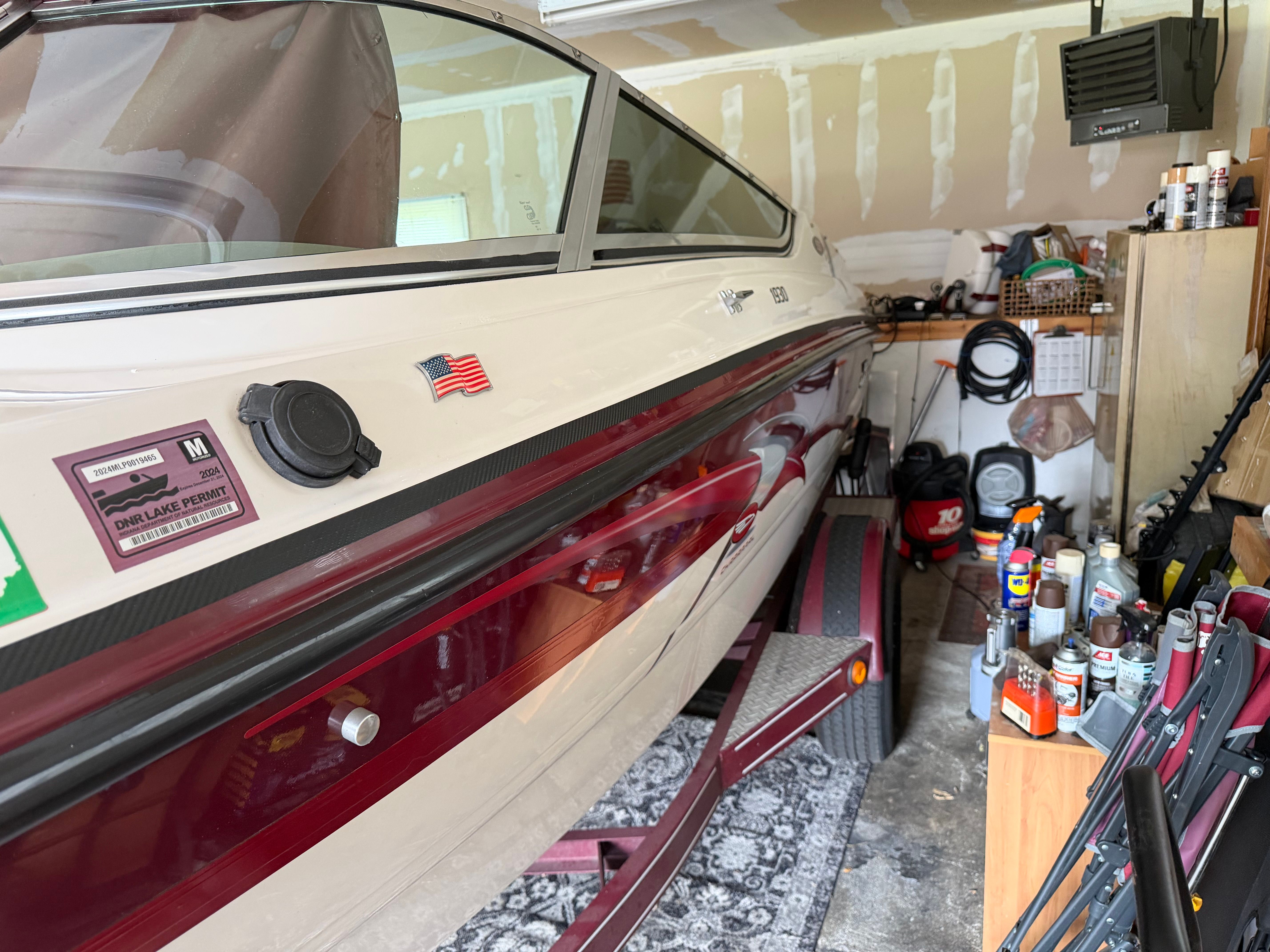A 1994 Chaparral 1930 boat in a garage. It features a white and red paint scheme.