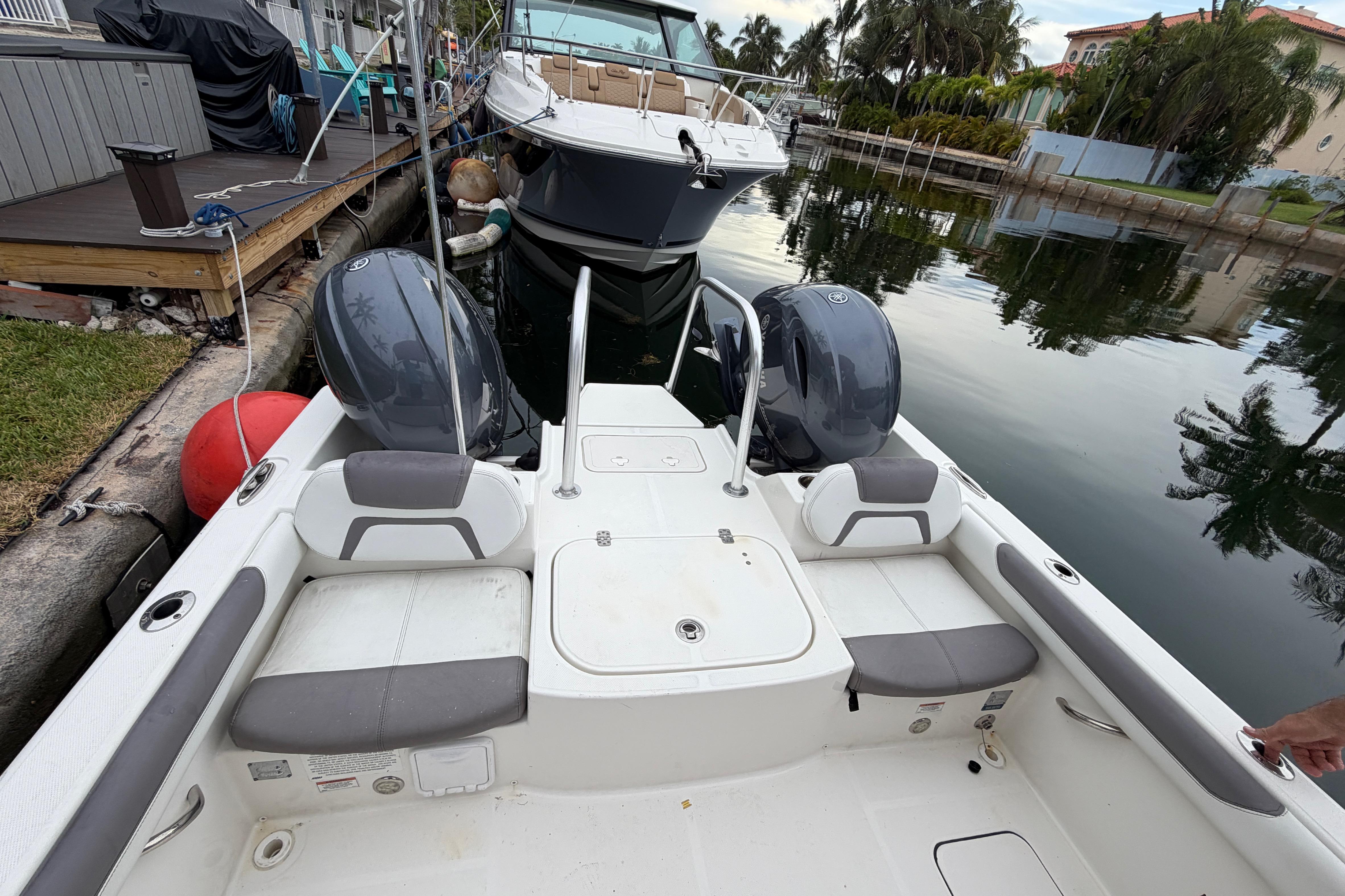 2019 World Cat 230 DC boat docked in a serene canal setting.