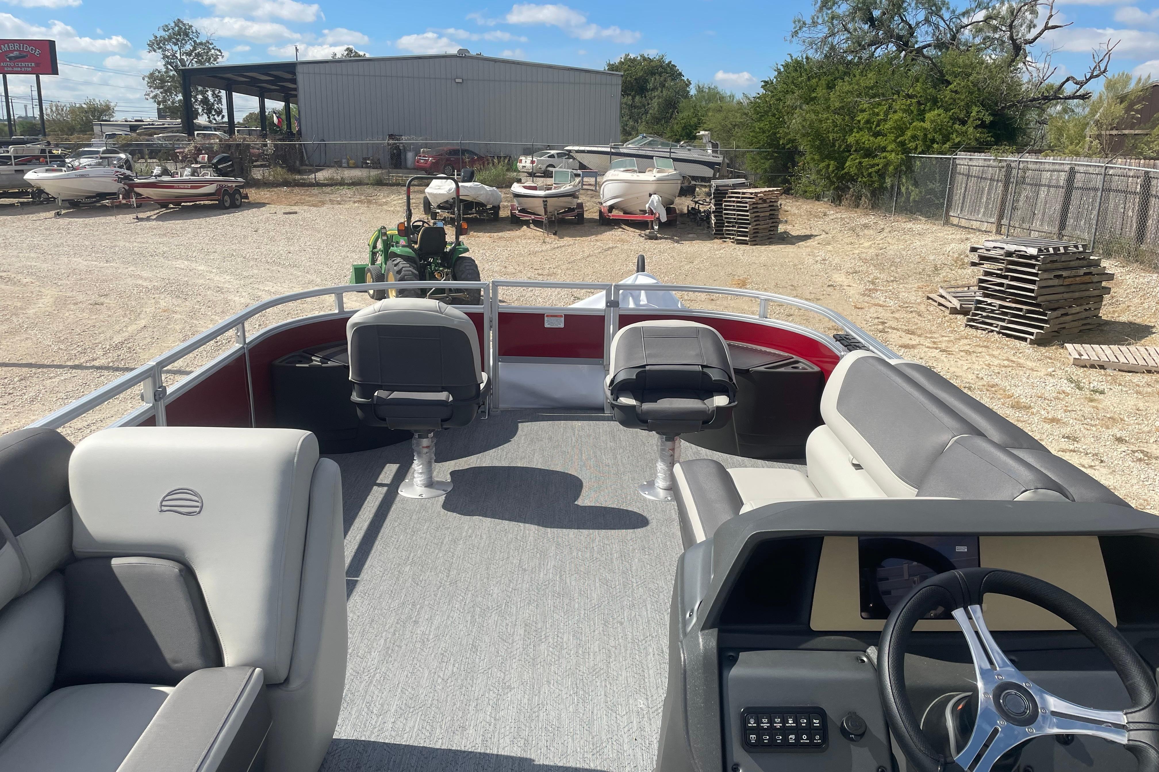 2026 Sun Tracker Fishin' Barge 22 DLX pontoon boat interior with seating and steering wheel.