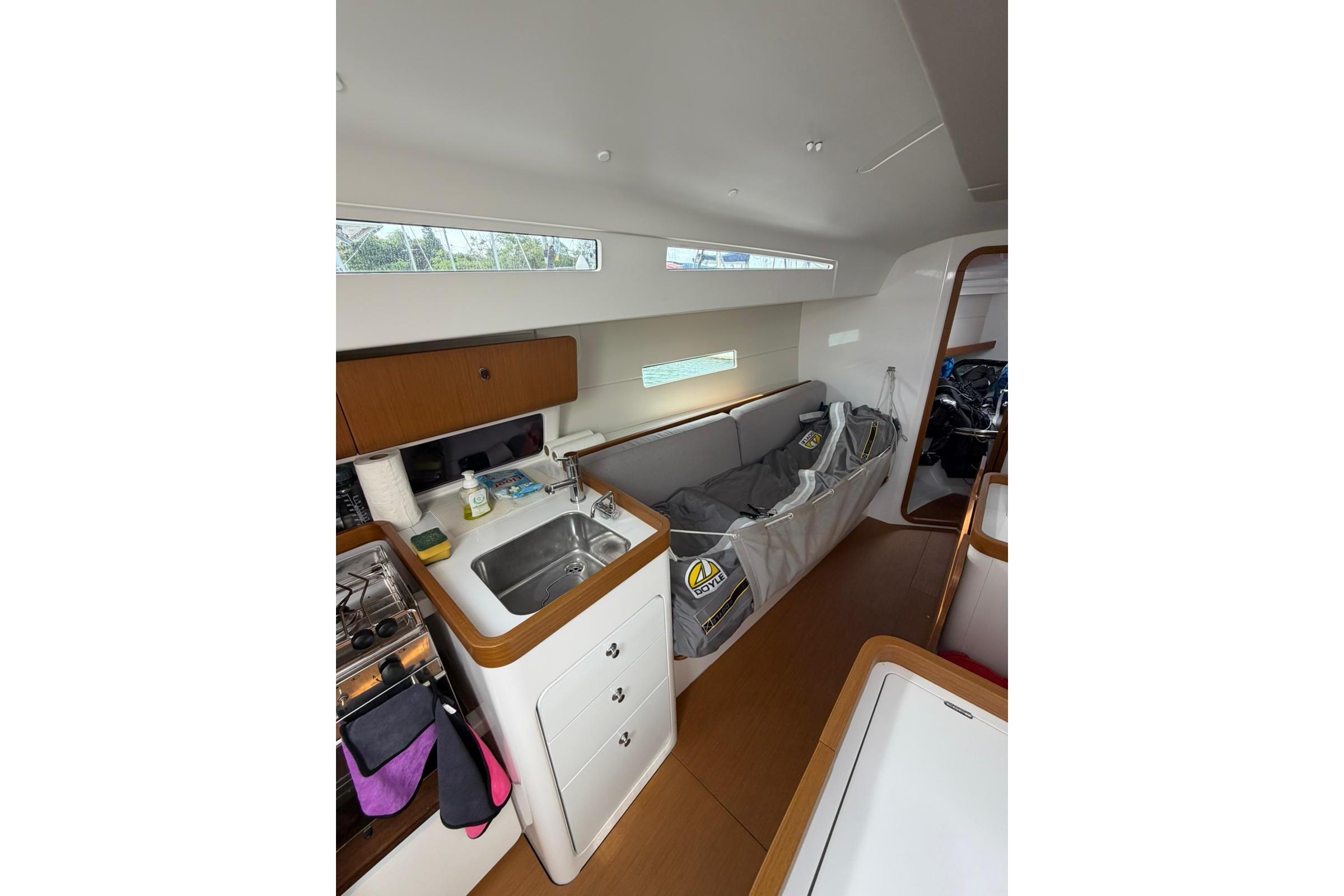 Interior of 2023 Beneteau First 36 sailboat, featuring modern kitchen and cozy seating area.