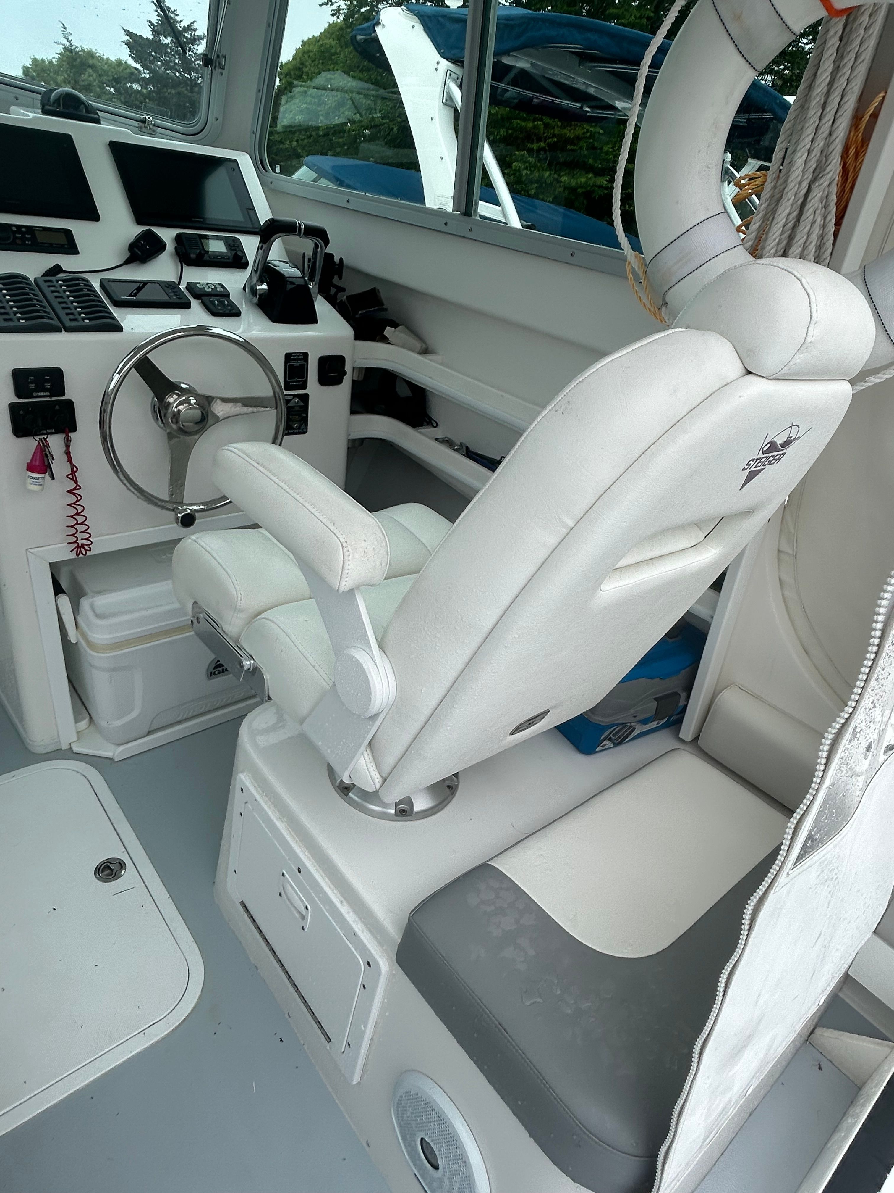 Interior of a 2019 Steiger Craft 28 Miami boat with helm and seating.