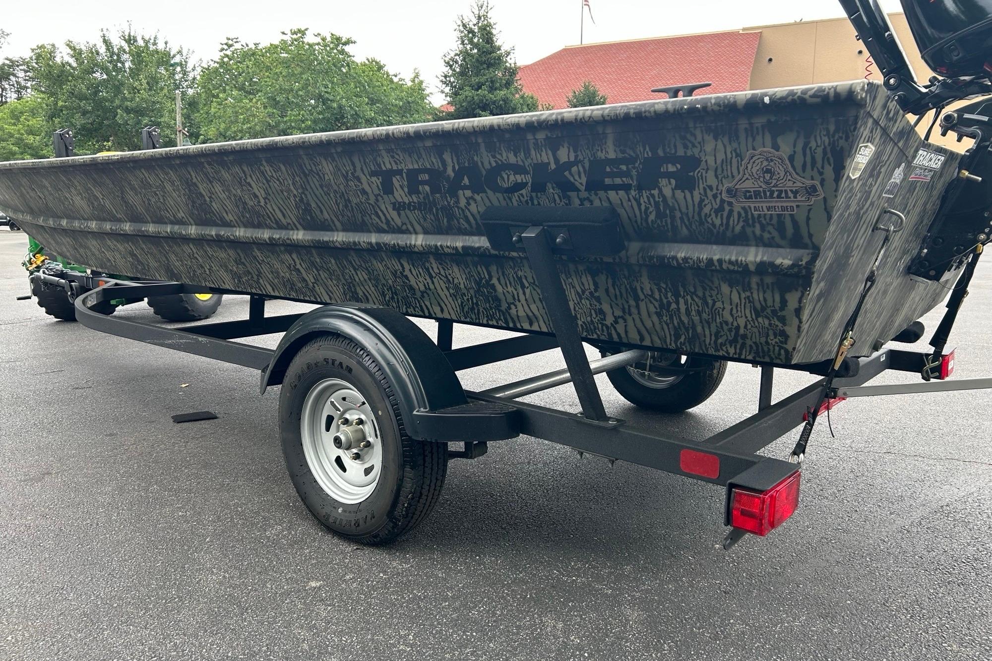 2025 Tracker Grizzly 1860 AWL boat on trailer, parked outdoors.