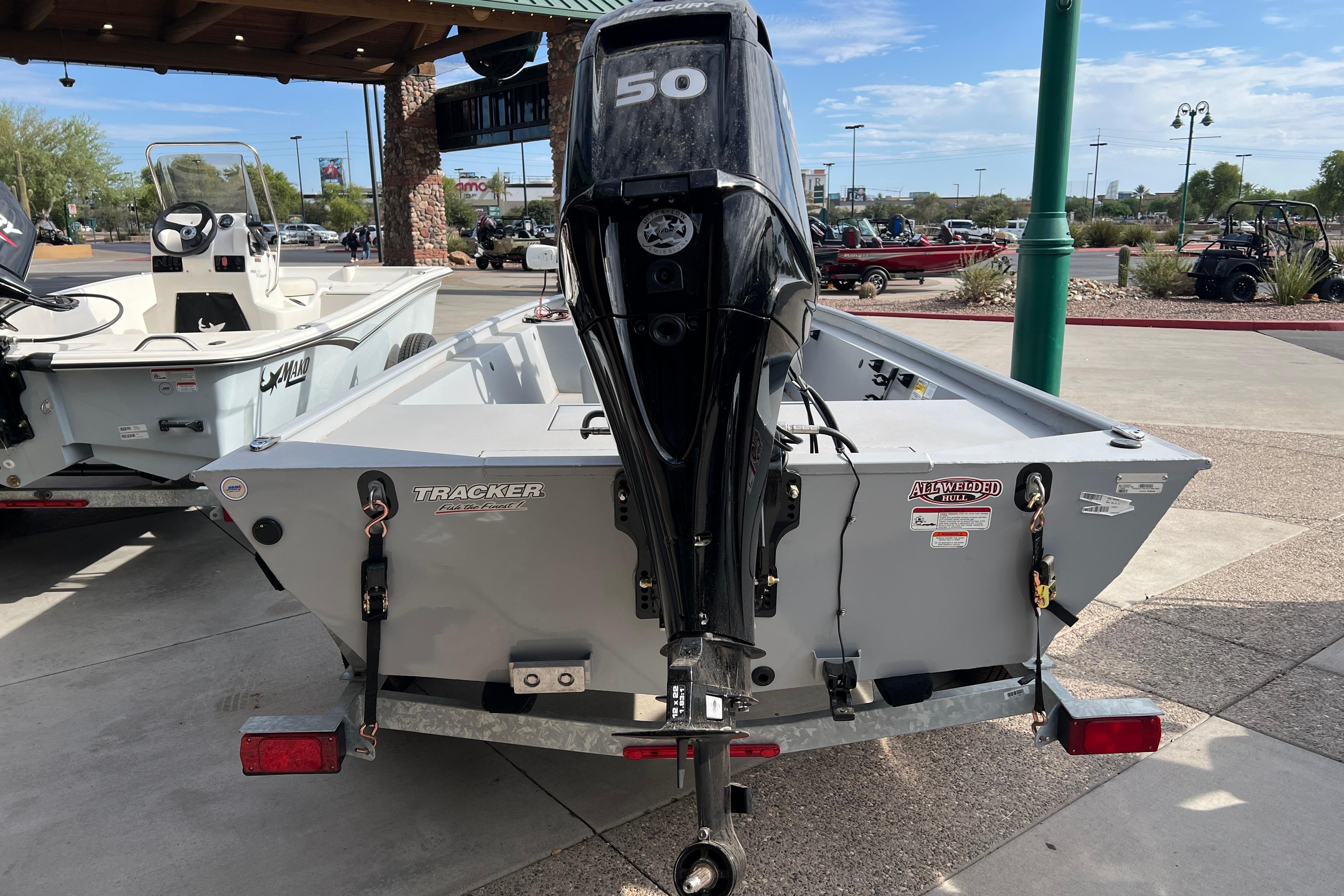 2026 Tracker Bass Tracker Classic CC boat with 50 HP engine, parked outdoors.