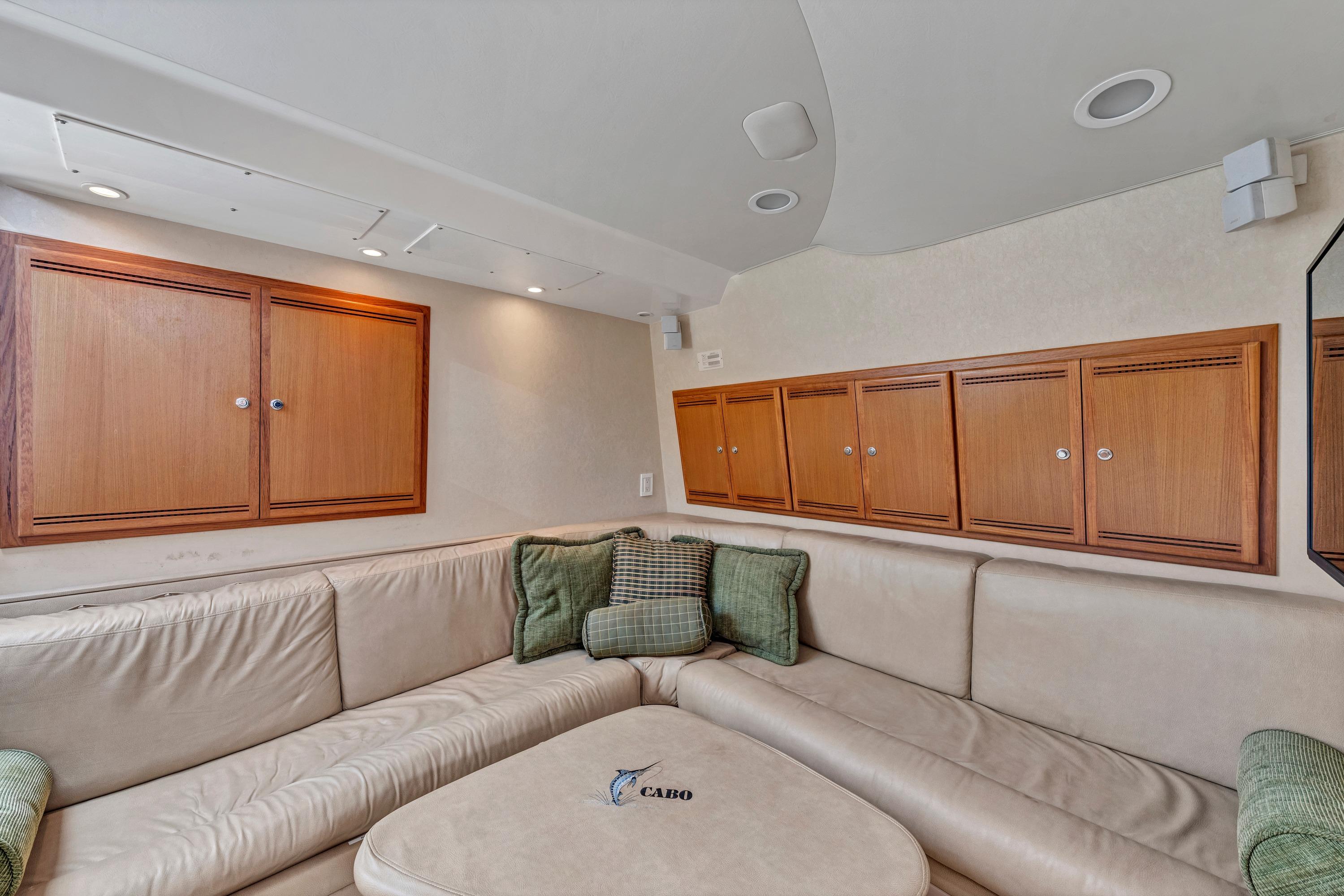 Luxurious interior of 2010 Cabo 45 Express yacht with beige seating and wooden cabinets.