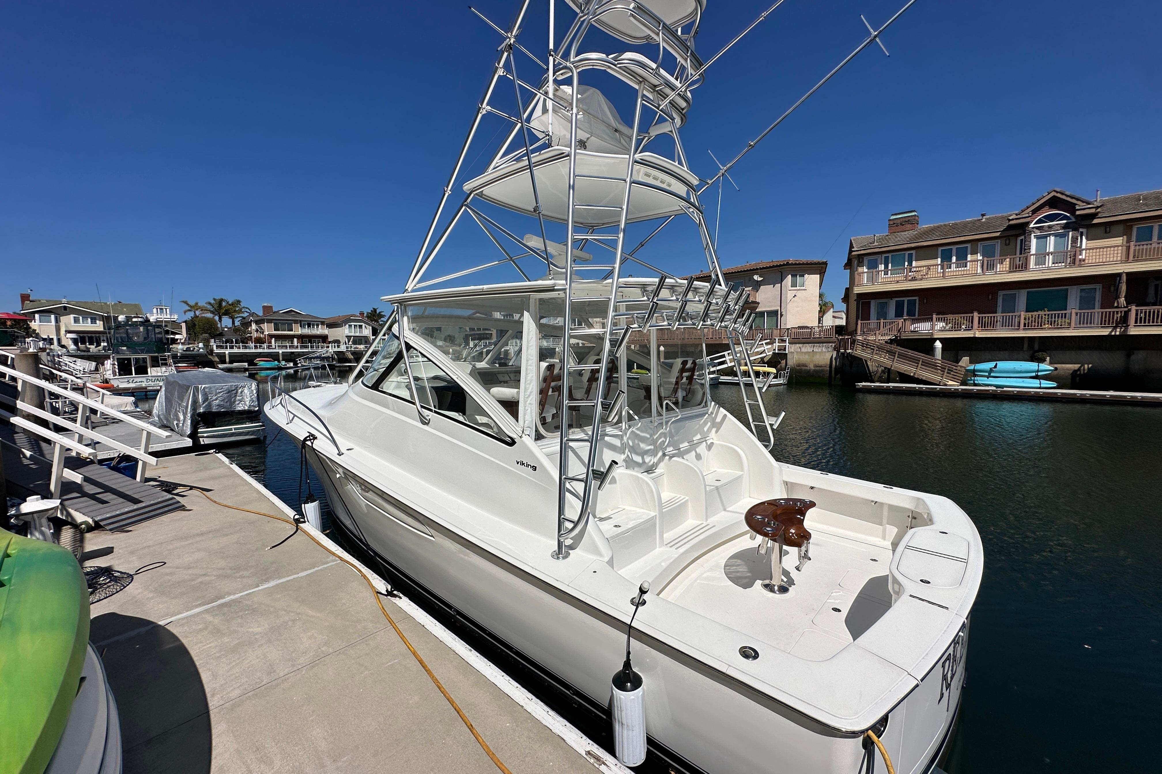 2012 Viking 42 Open yacht docked at marina under clear blue sky.