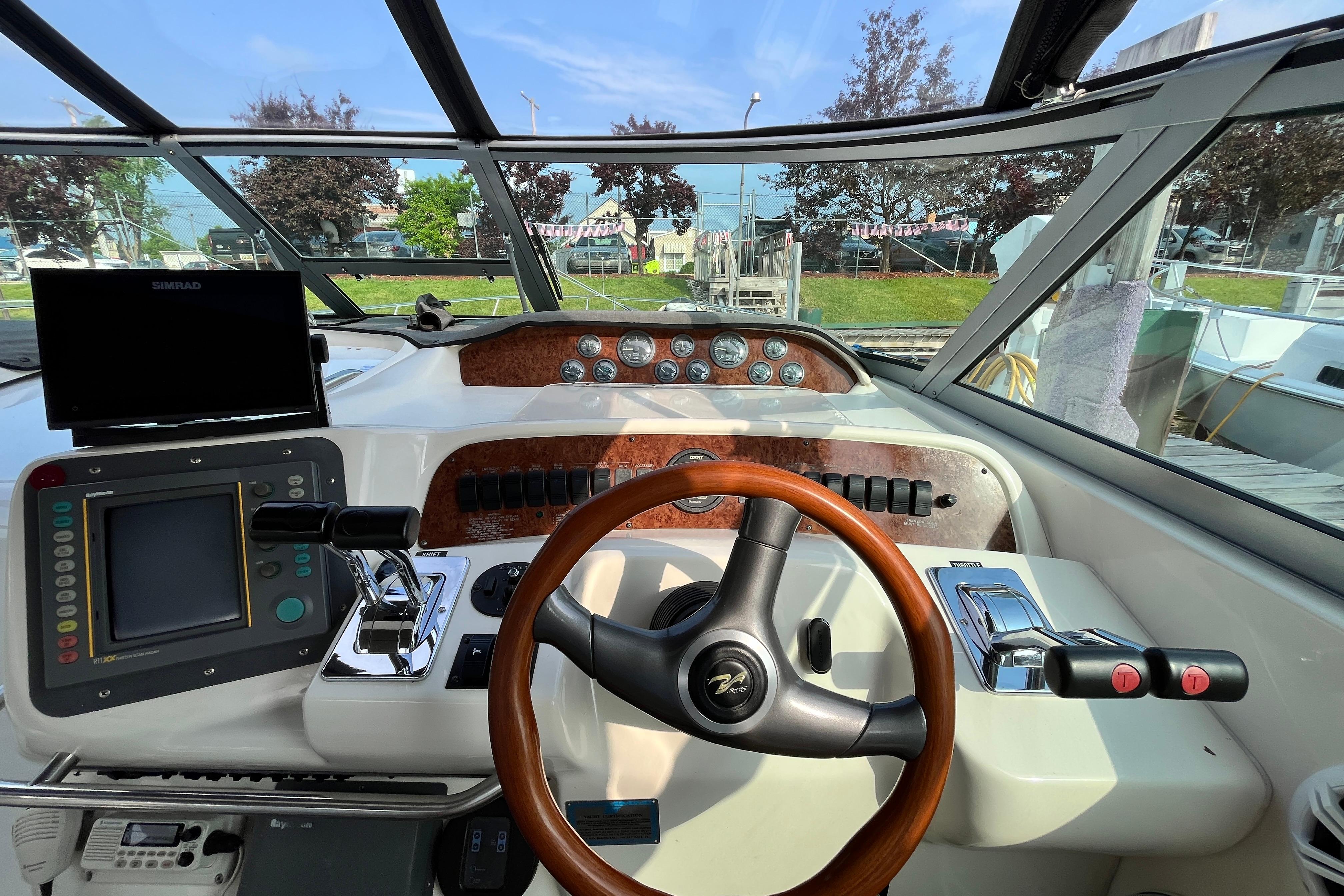 1995 Sea Ray Sundancer 330 helm with steering wheel, controls, and navigation equipment.