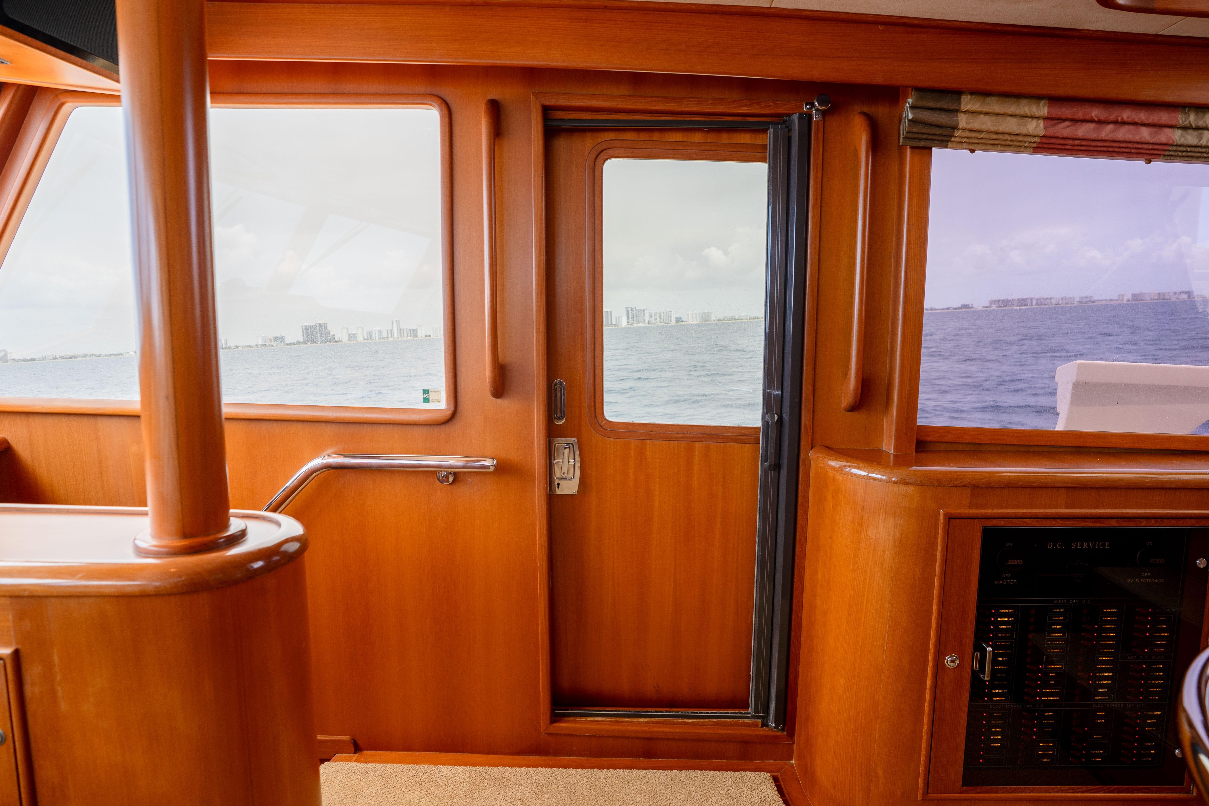 Interior view of 2006 Fleming 75 yacht with ocean and cityscape through windows.