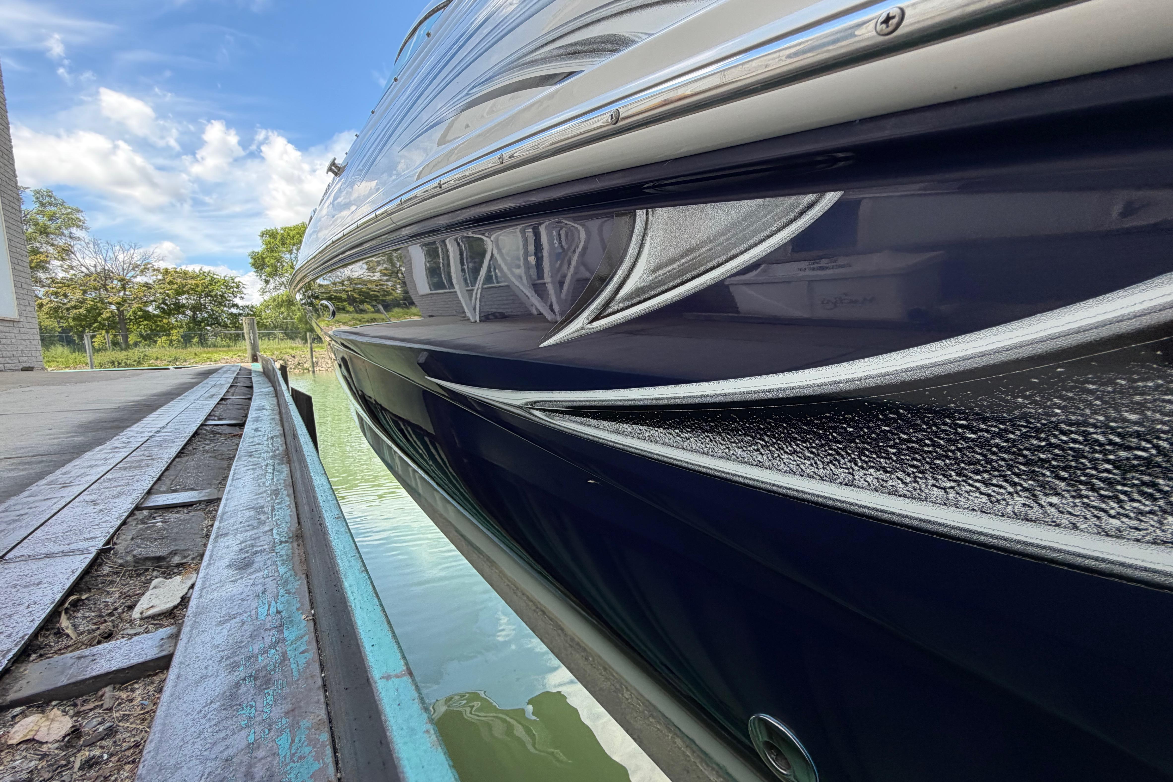 2004 Sea Ray 240 Sundeck boat docked, showcasing sleek design and reflective water surface.