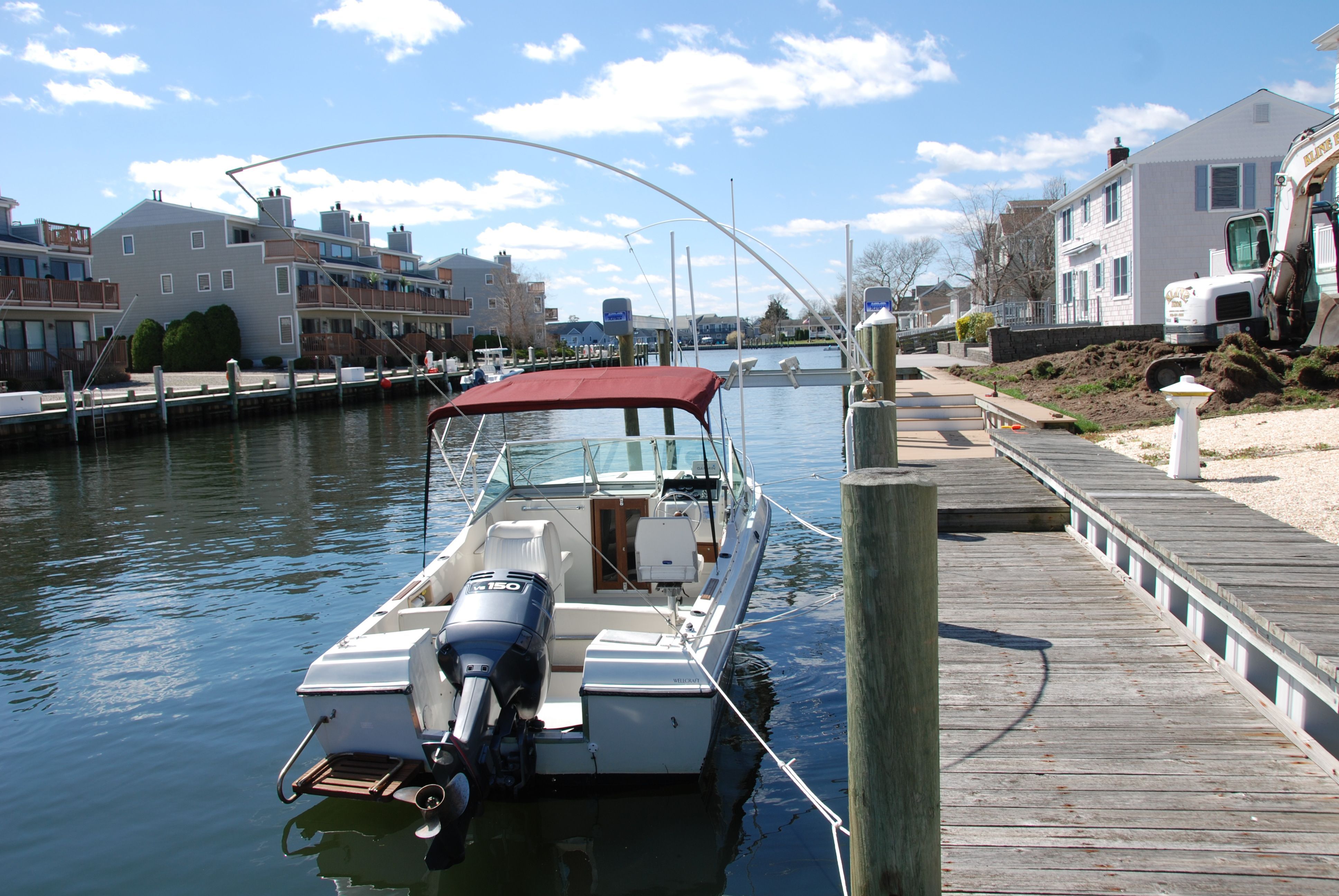 A 1987 Wellcraft V-20 Steplift docked in a calm residential area.