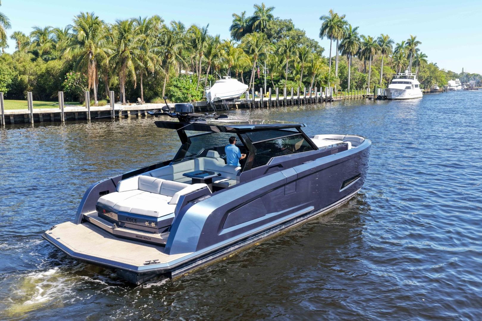 2022 Vanquish Yachts VQ45 cruising on a scenic waterway with lush palm trees.
