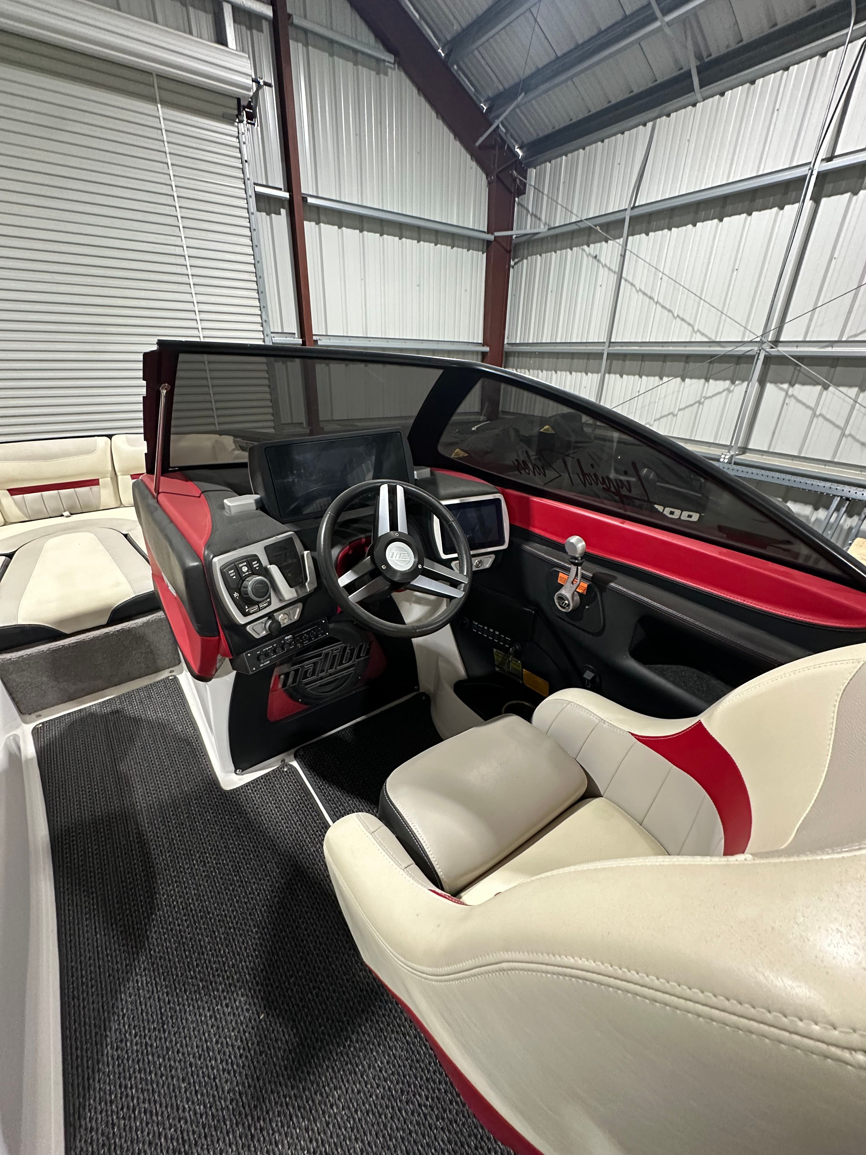 The interior of a Malibu Wakesetter 24 MXZ boat with red and white seating.