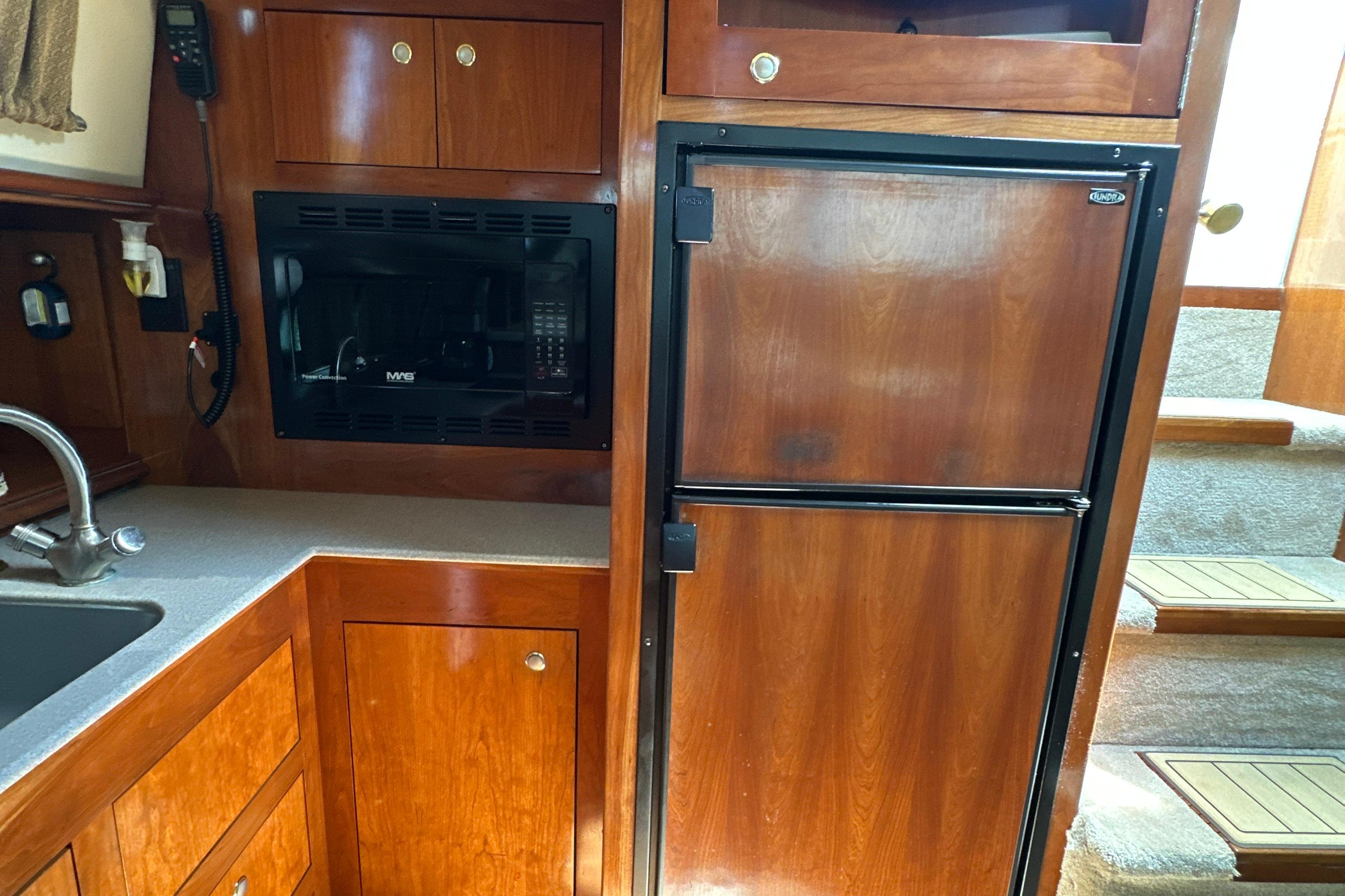 2004 Cruisers Yachts 405 Express Motoryacht kitchen with wood cabinetry and appliances.