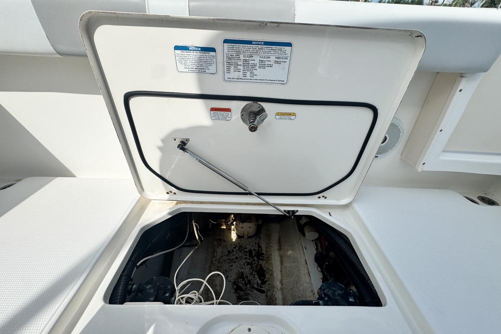 Open hatch on 2018 Mako 284 Center Console boat, revealing storage compartment.