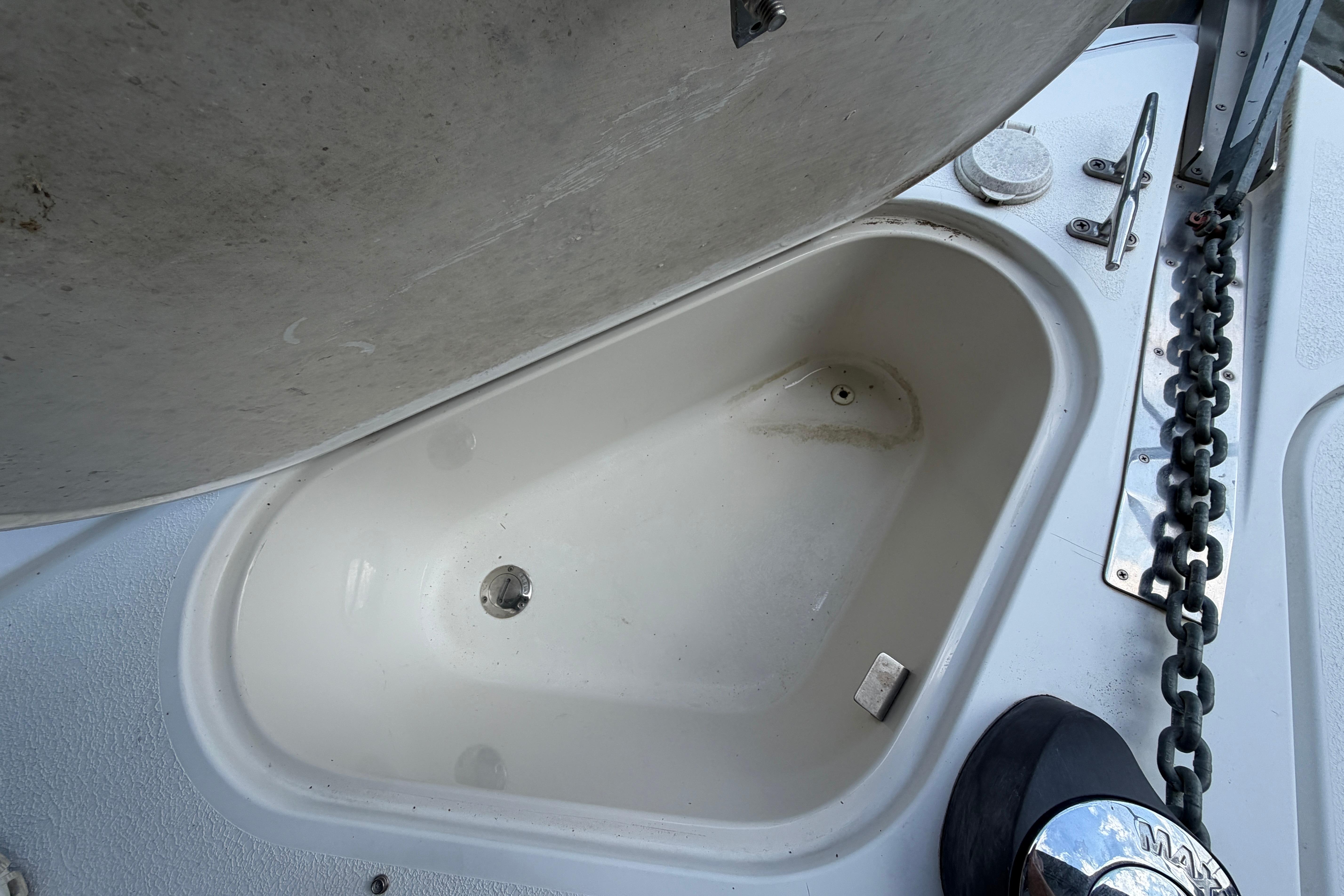 Open storage compartment on 2000 Carver 350 Mariner boat deck with chain and winch.