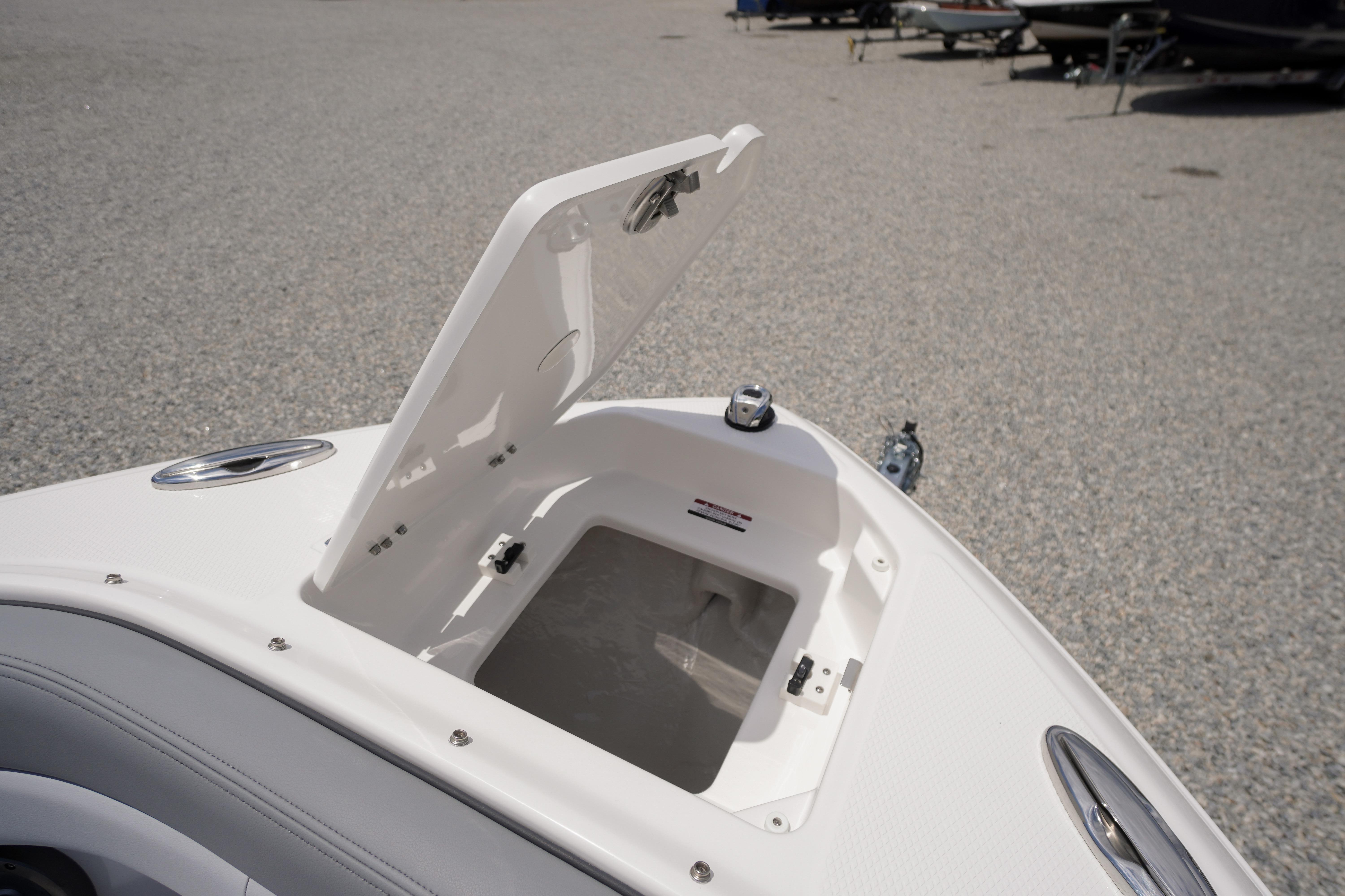Open storage compartment on 2026 Chaparral SSX 4 boat, showcasing sleek design and functionality.