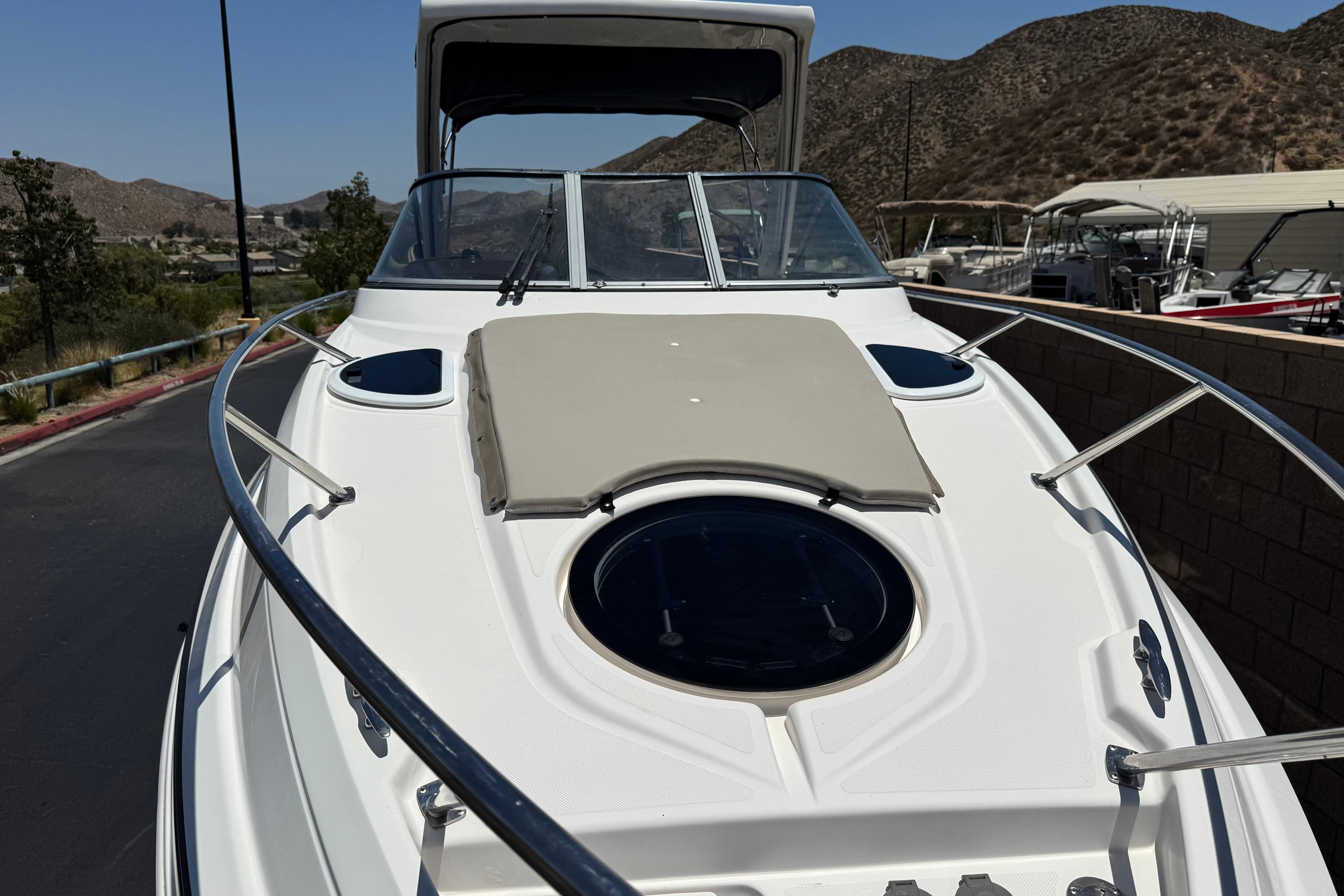 2013 Regal 28 Express boat with sleek design, docked near scenic hills.