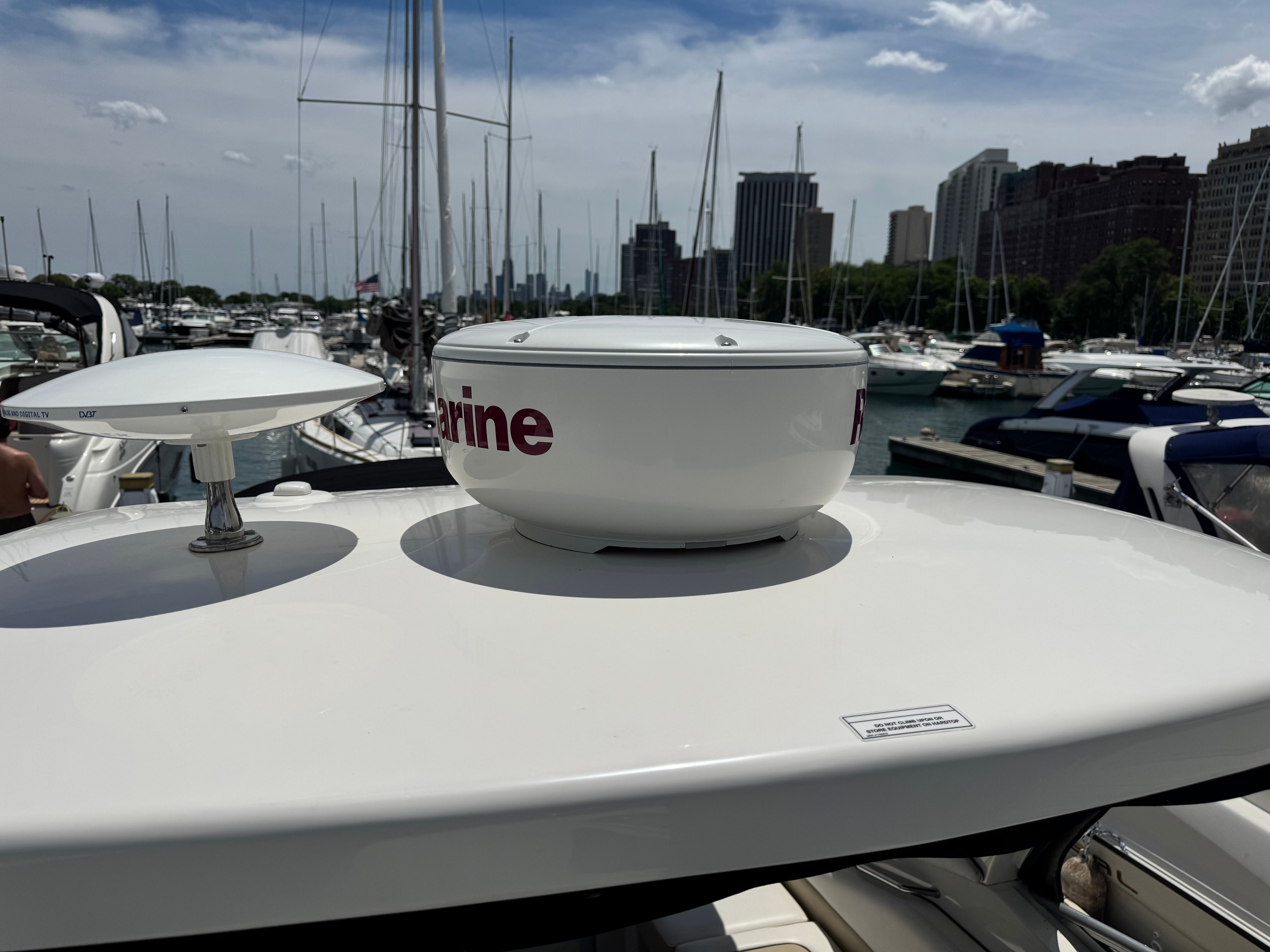 A 2010 Sea Ray Sundancer 310 in a marina, surrounded by other boats.