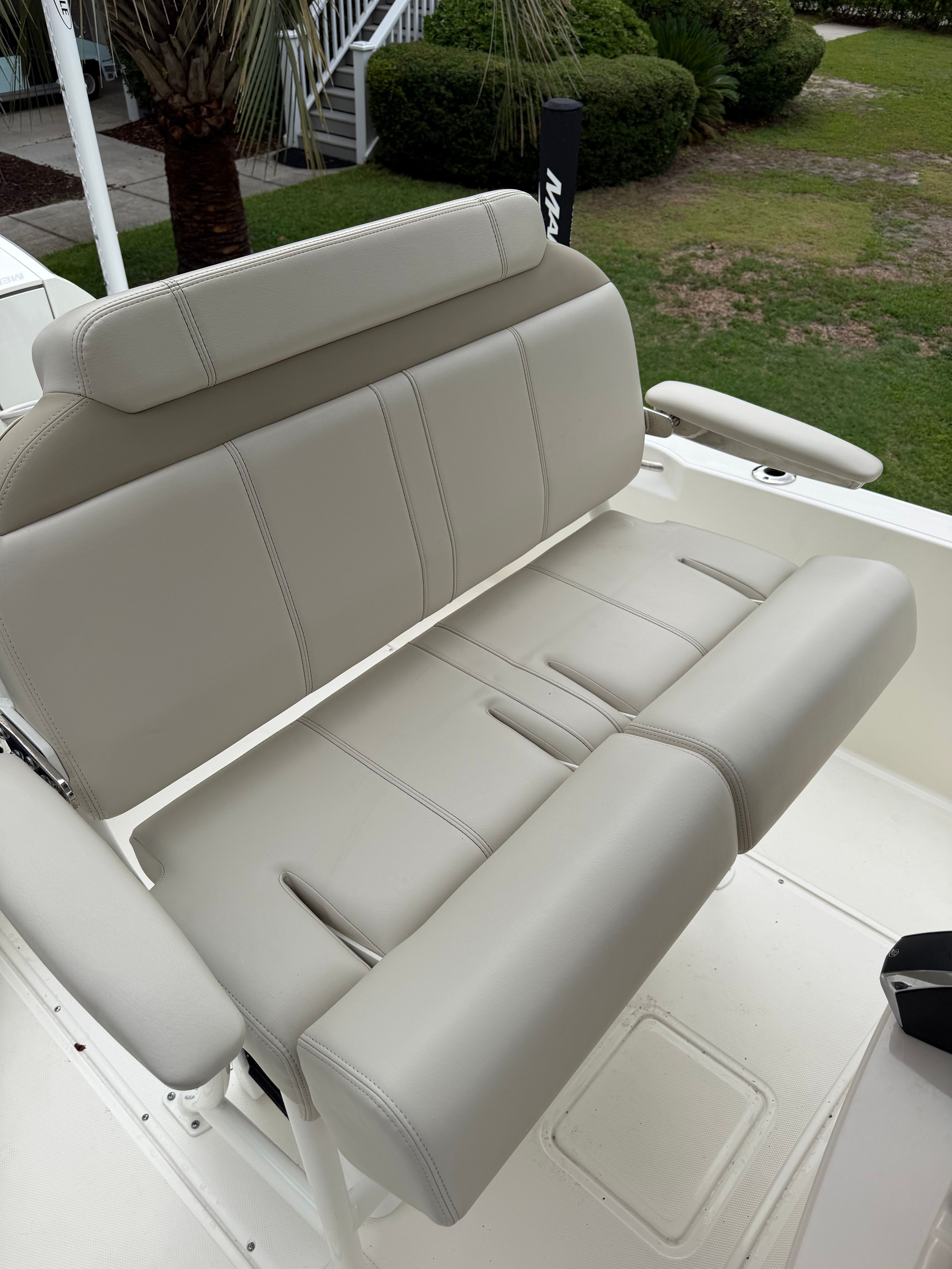 The 2025 Boston Whaler 220 Dauntless features a cushioned bench seat with armrests.