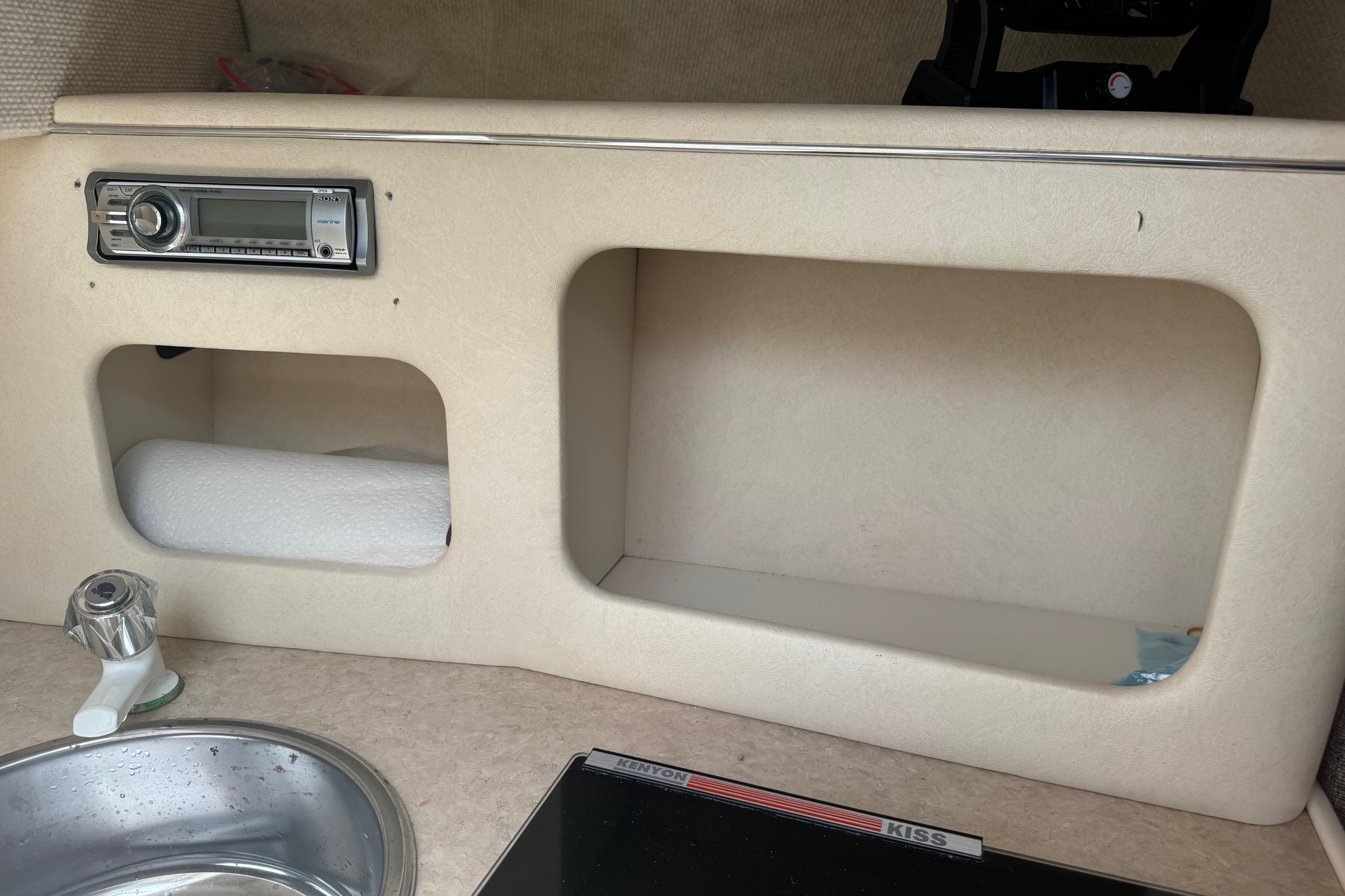 Interior of 2001 Sea Ray 245 Weekender with sink, stereo, and storage compartments.