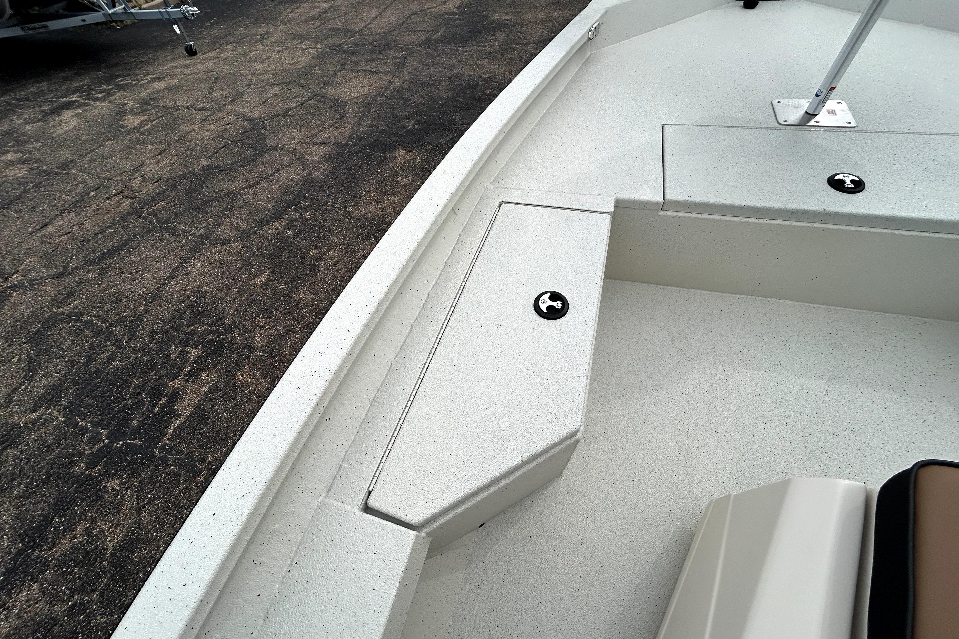 2026 Xpress H20B Bay boat interior with storage compartments on a textured surface.