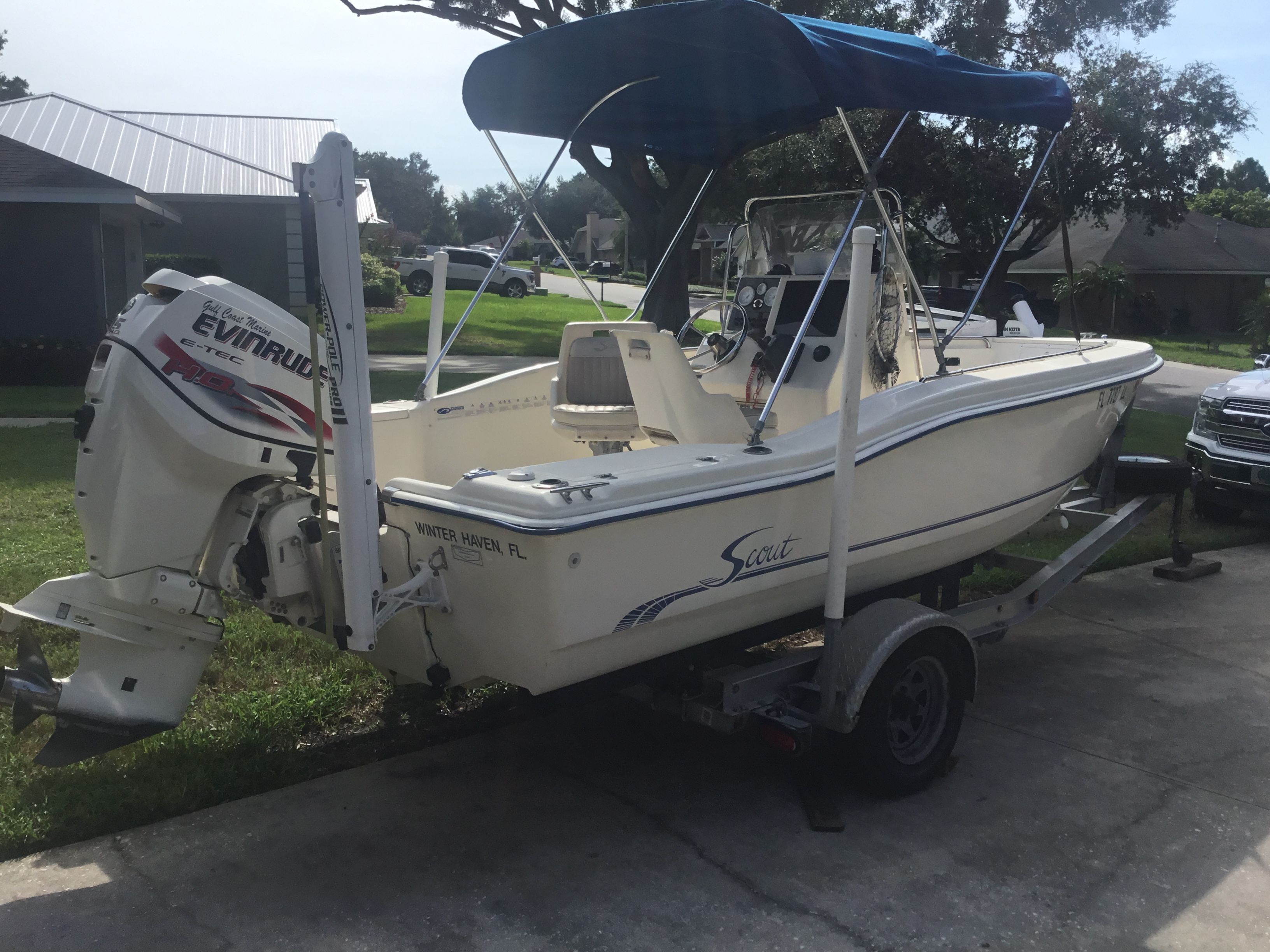 2001 Scout 18-5 center console on a trailer, featuring a blue sunshade and Evinrude motor.