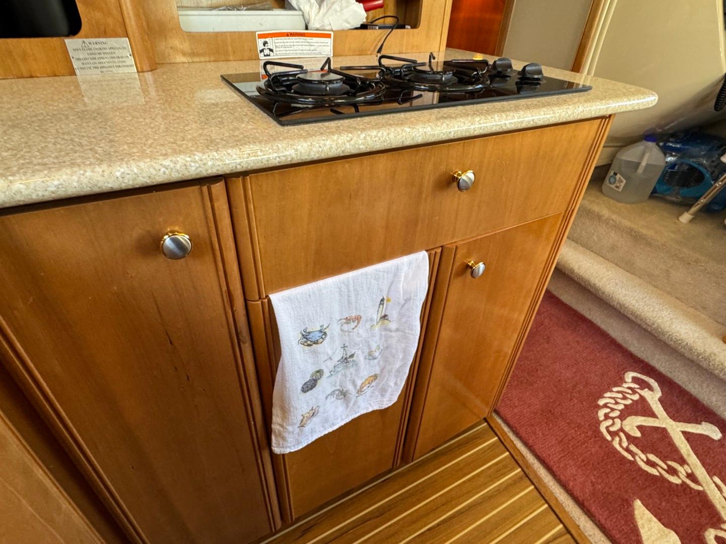 Wooden kitchen cabinetry with stove in 2003 Meridian 381 Sedan yacht interior.