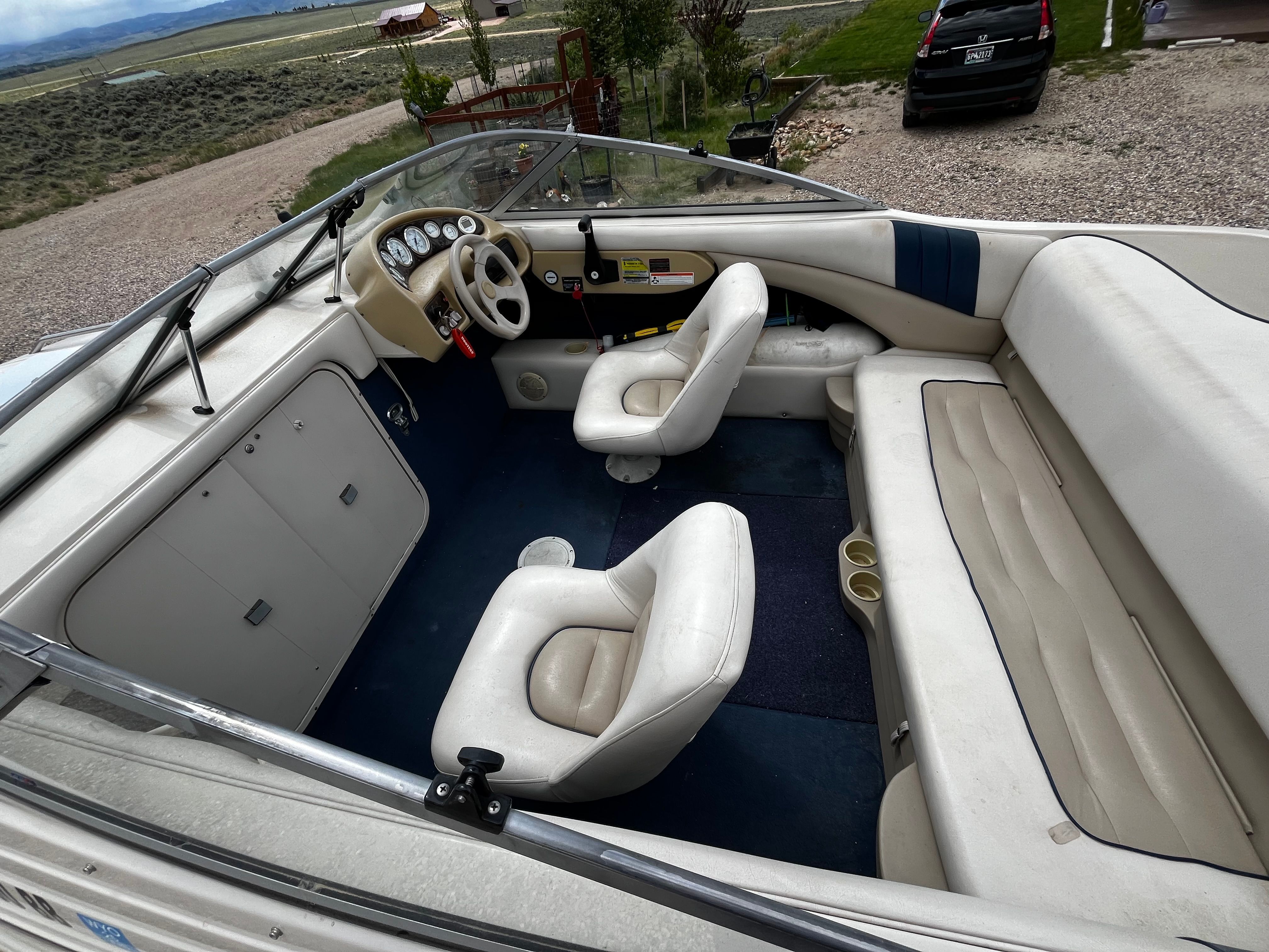 The image shows the interior of a 1998 Glastron SE199 boat with two seats and a helm.