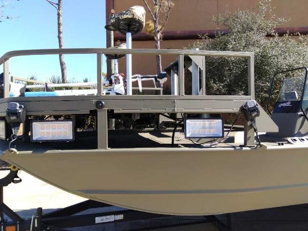 2024 Tracker Grizzly 2072 CC Sportsman boat with mounted lights and railing.