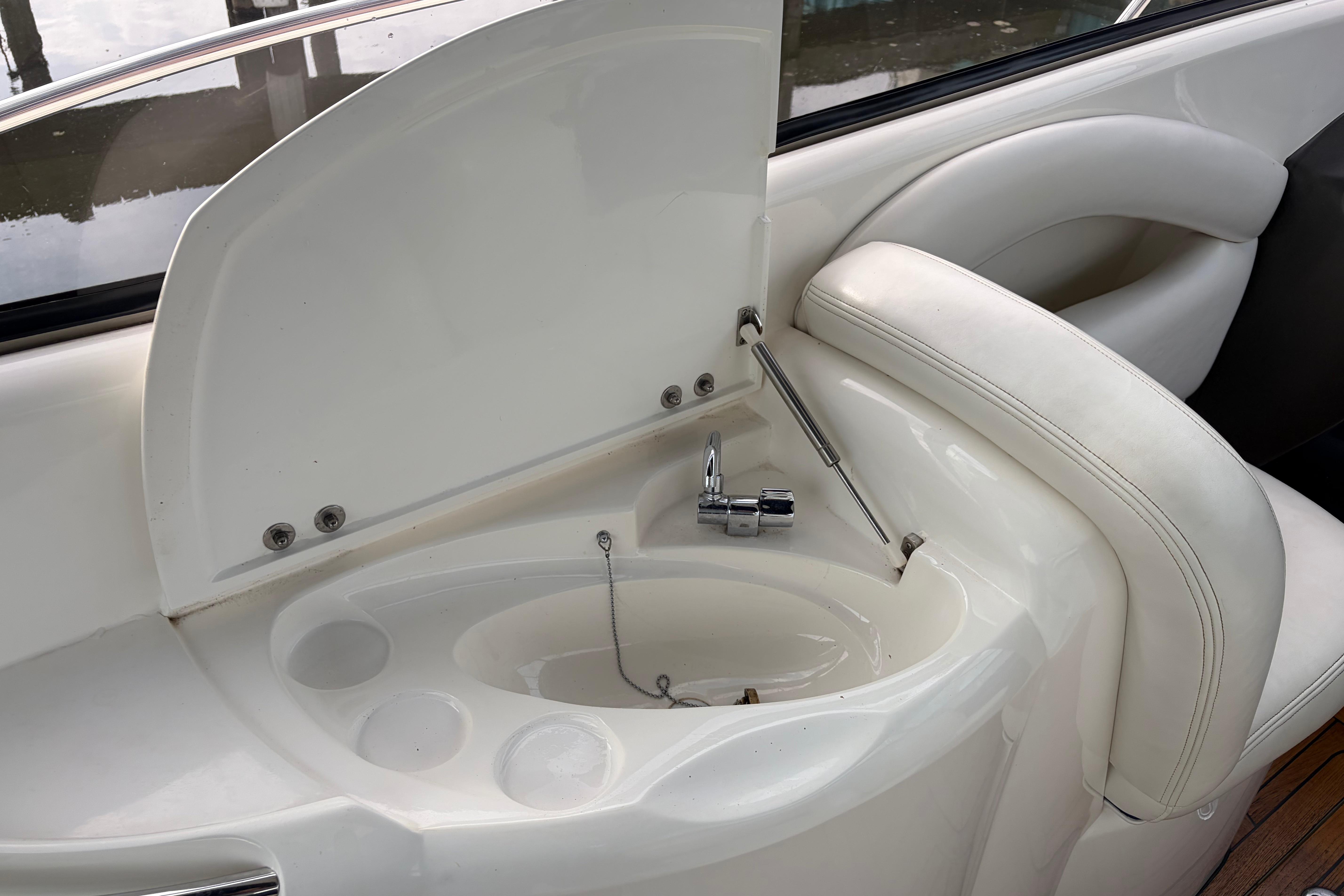 Interior sink area of a 2000 Sunseeker Superhawk 34 yacht, featuring sleek white design.