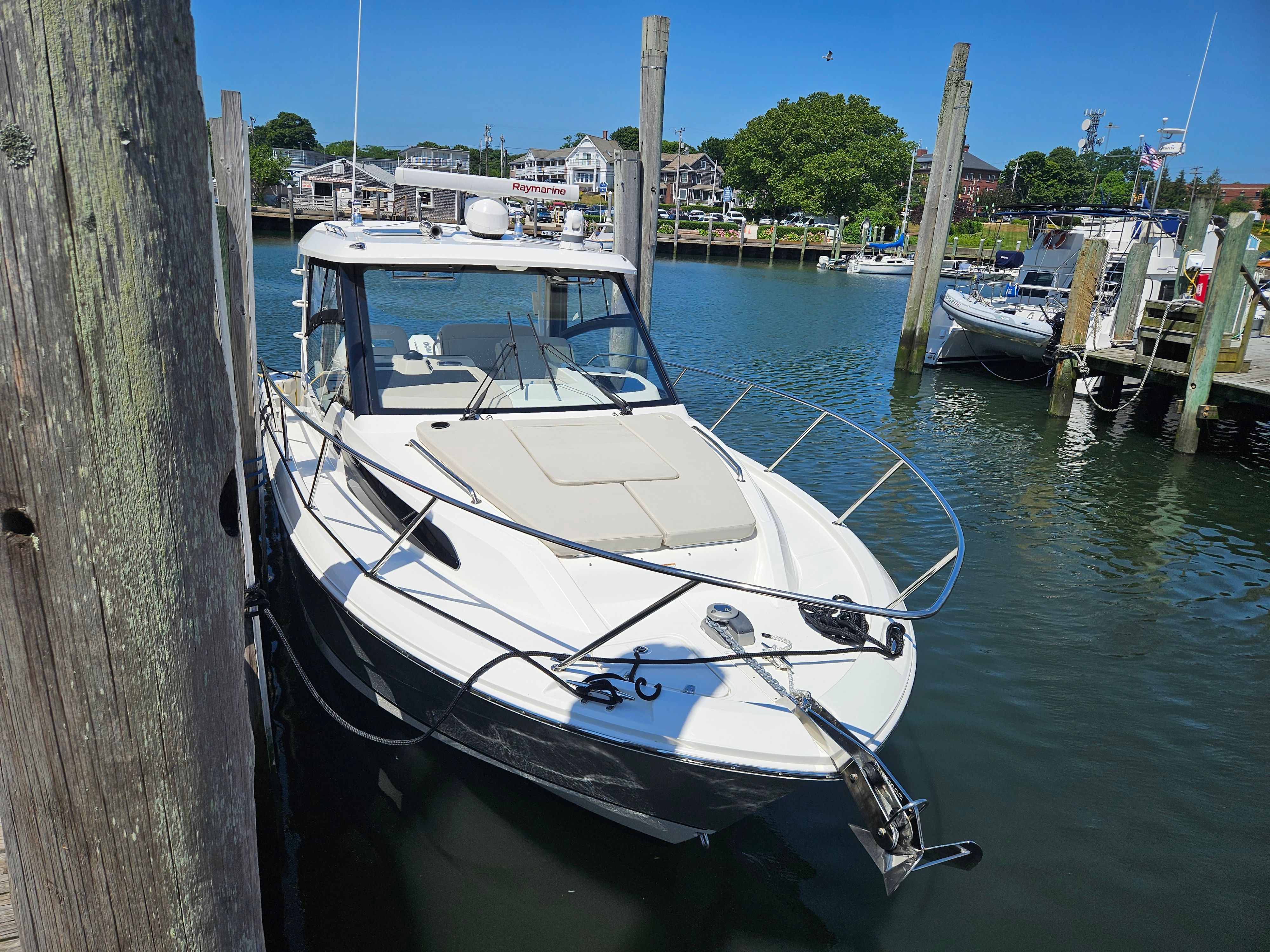 A 2023 Boston Whaler 325 Conquest docked in a calm harbor setting.