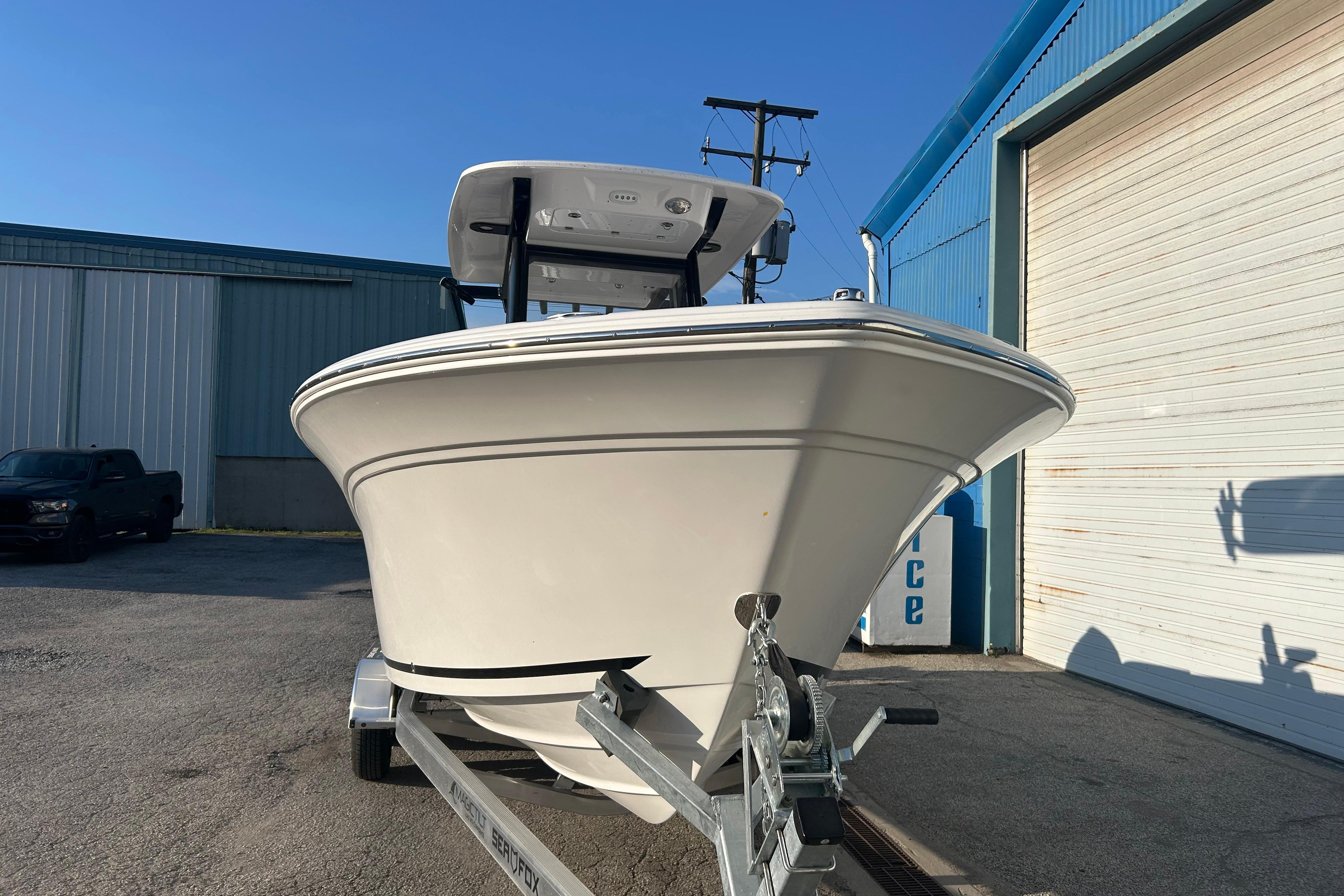 2026 Sea Fox 248 Commander boat on trailer outside a blue warehouse.