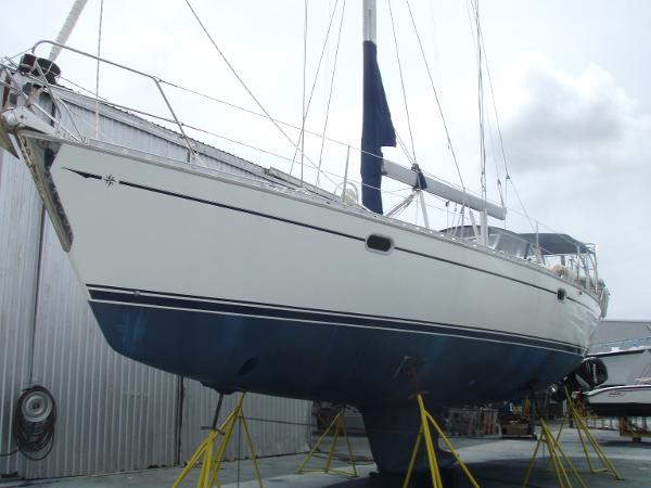 2001 Jeanneau 45.2 sailboat on stands, white hull, blue bottom, in a boatyard.