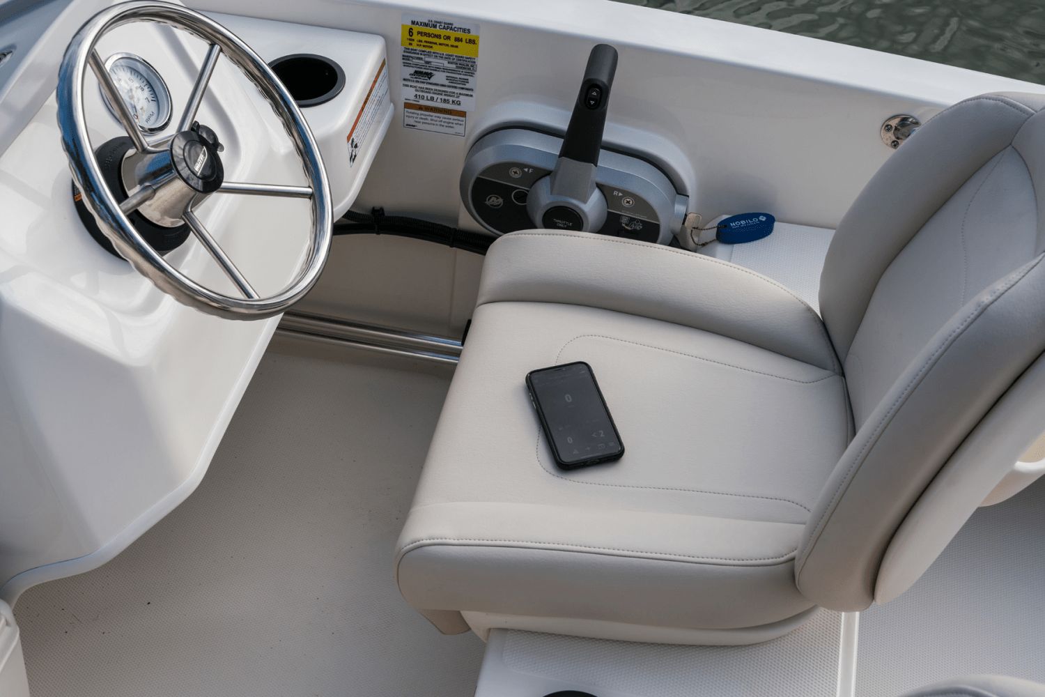 Interior view of a boat with a helm and a seat.
