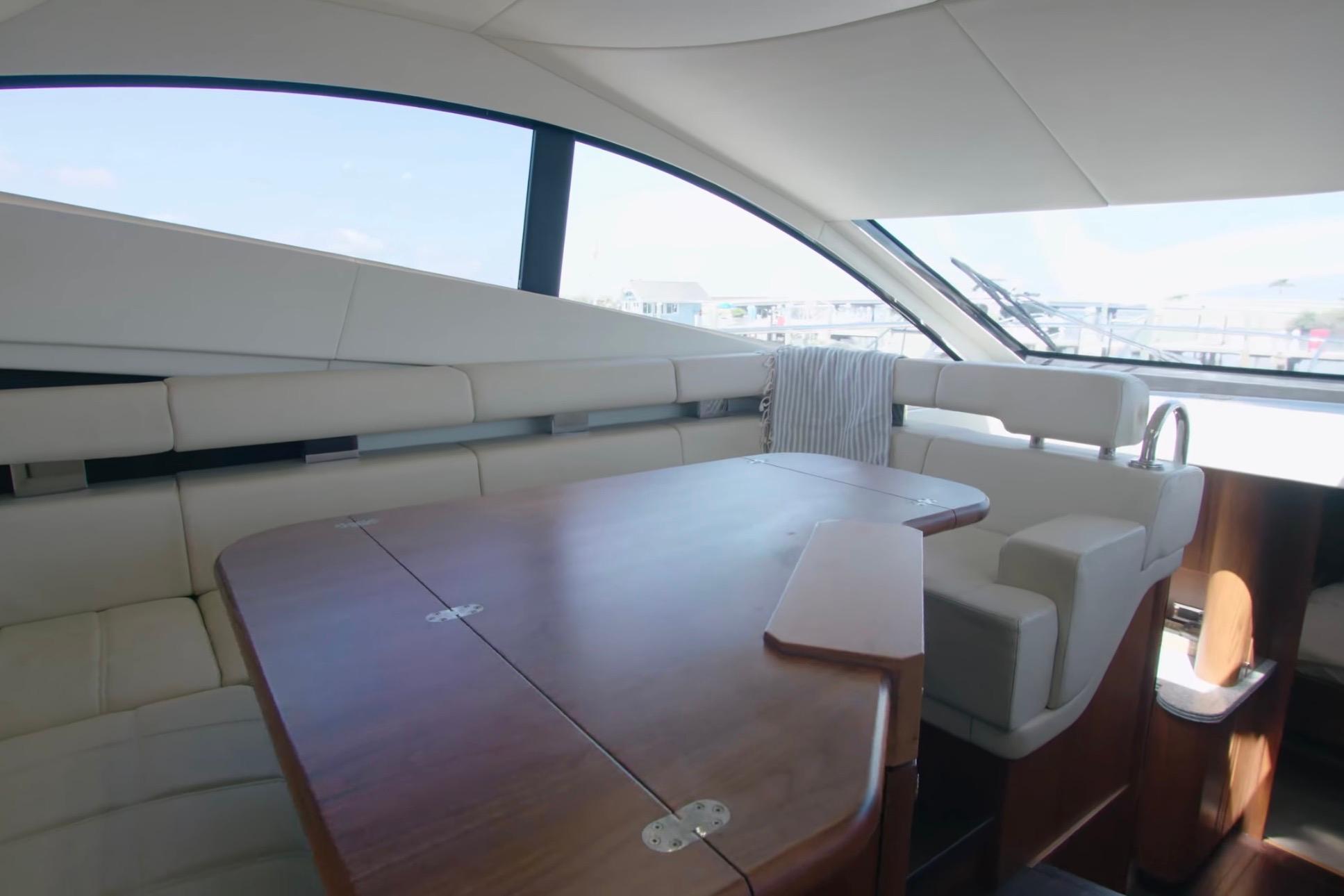 Luxurious interior of 2014 Sunseeker Manhattan 55 yacht with elegant seating and wooden table.