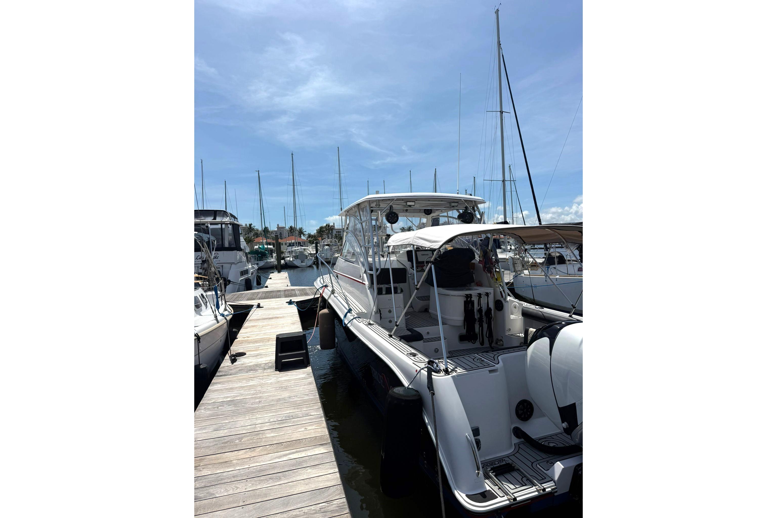 2006 Pro-Line 32 Express boat docked at marina under clear blue sky.