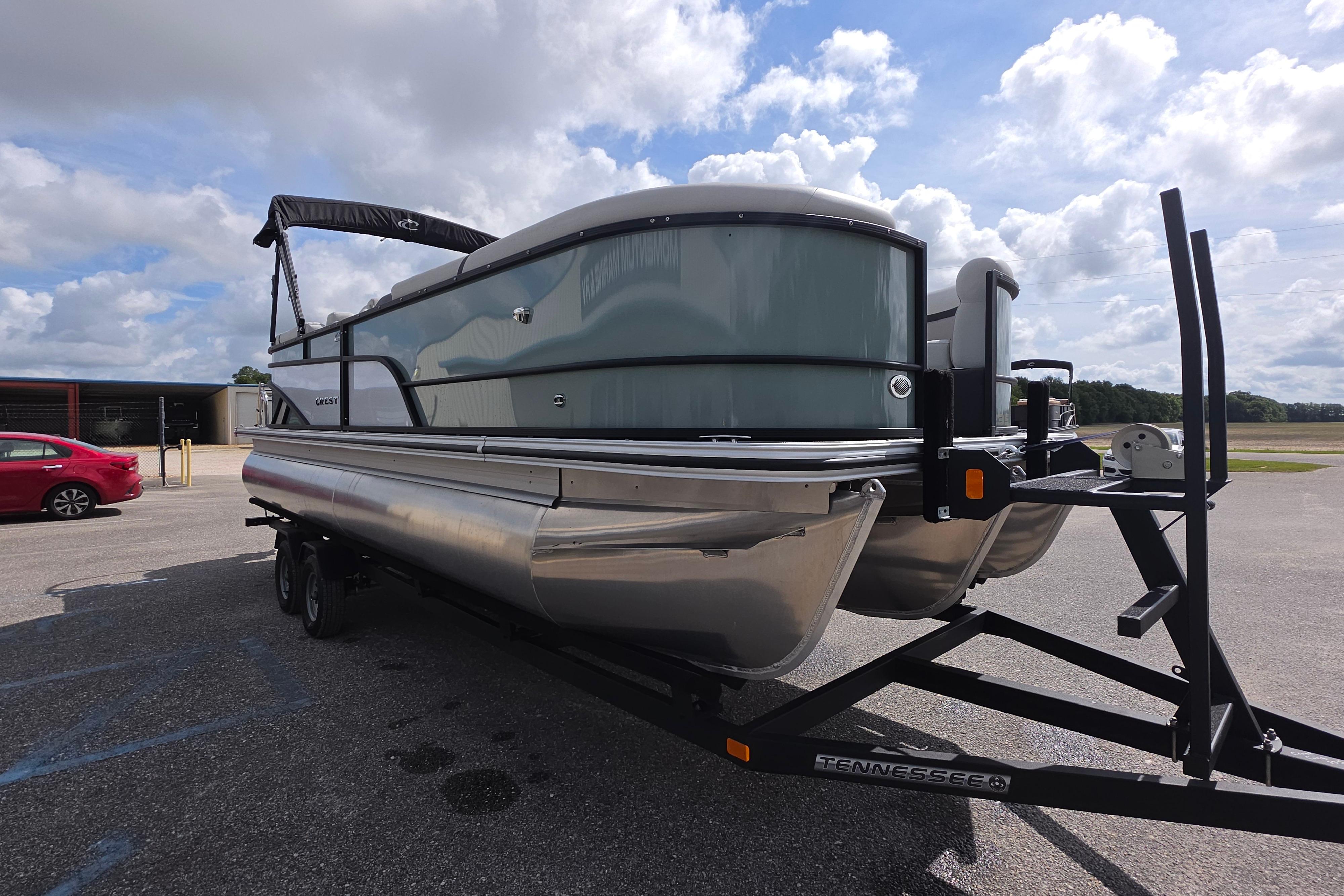 2026 Crest 235 Conquest SLC pontoon boat on trailer under cloudy sky.