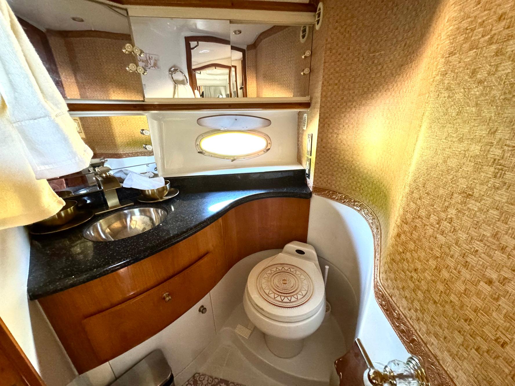 Luxurious bathroom in 2001 Carver 396 Motor Yacht with elegant fixtures and wood accents.