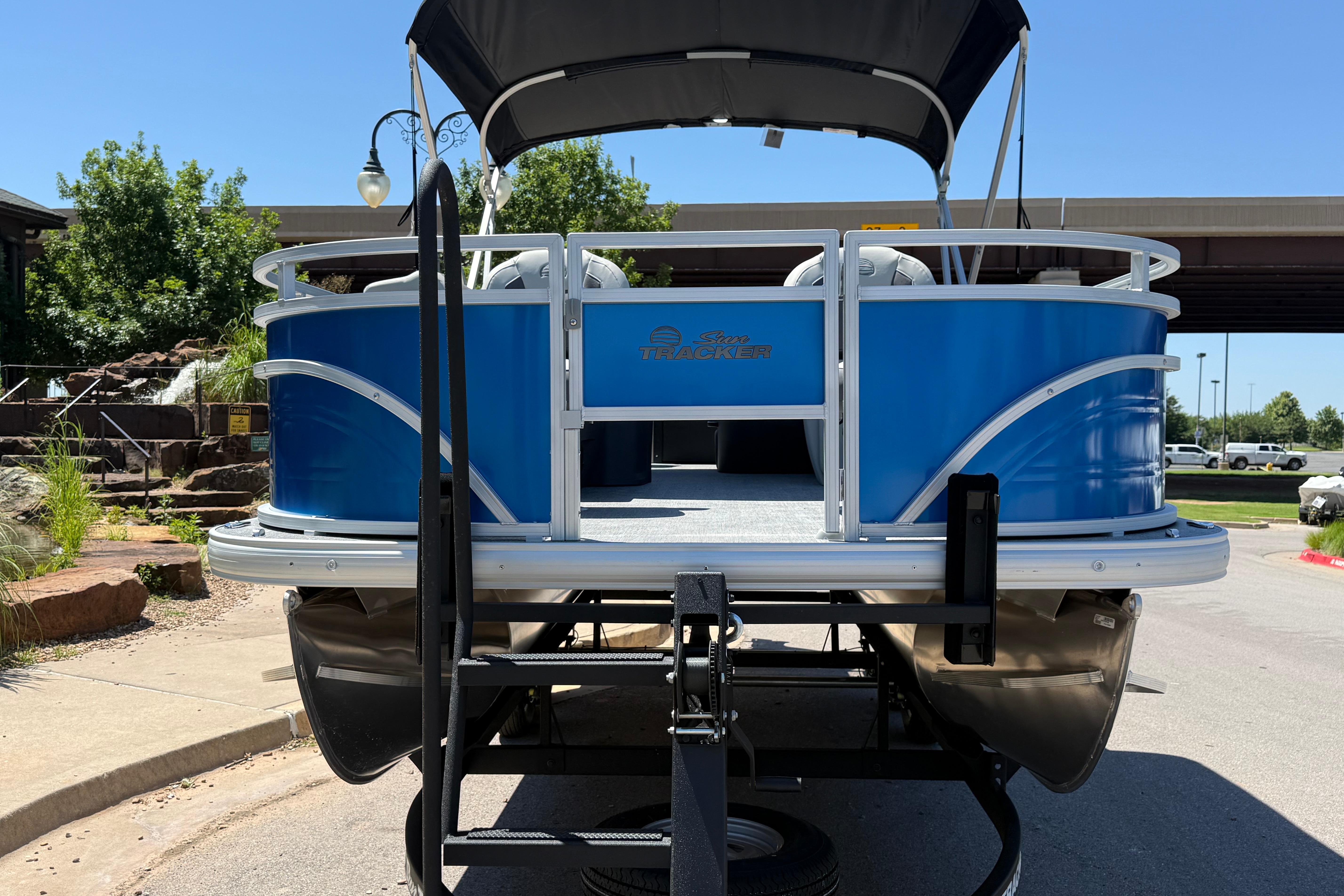 2026 Sun Tracker Fishin' Barge 20 DLX pontoon boat on trailer, outdoors.