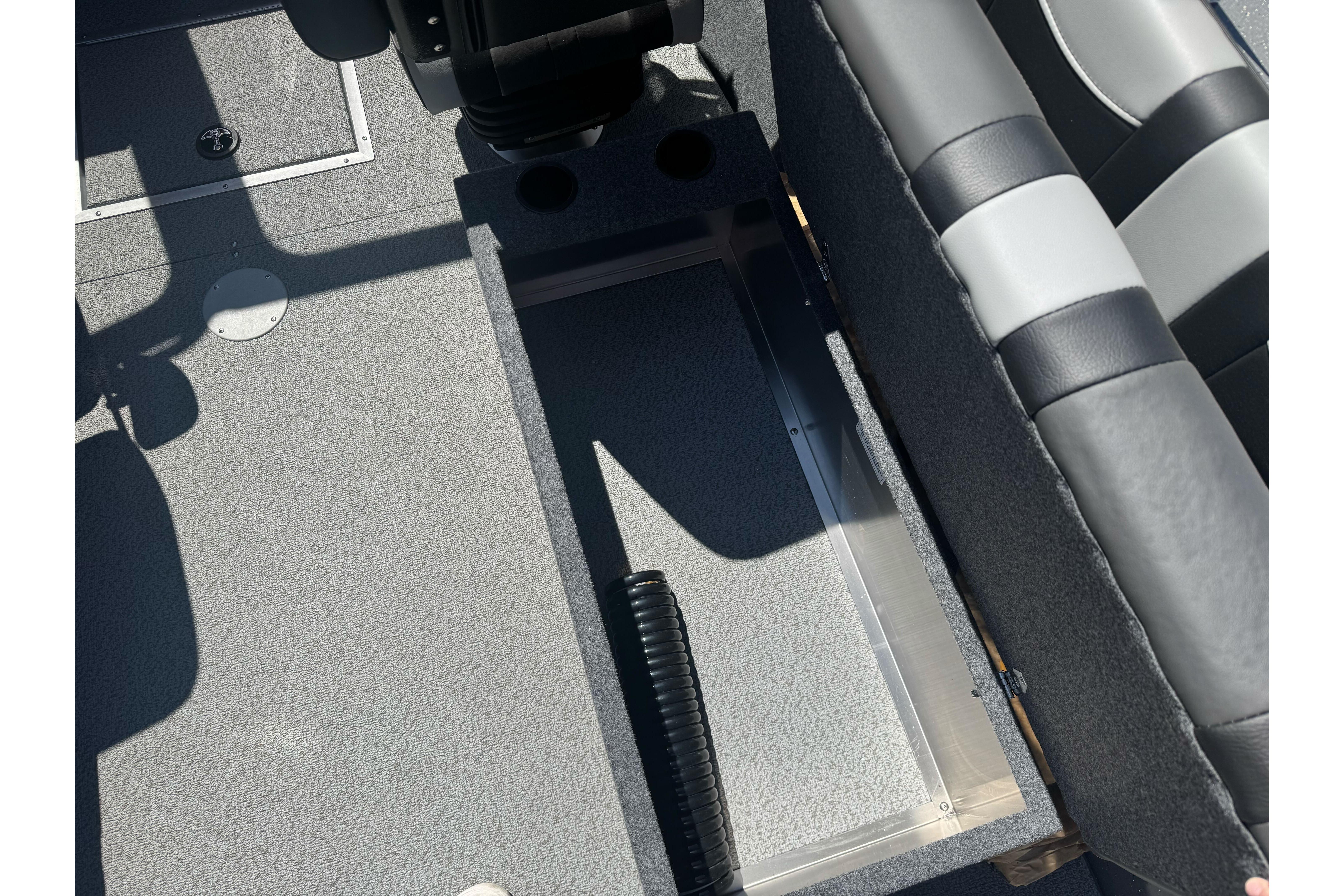 Interior view of 2026 Lund 210 Heavy Gauge boat, featuring seating and storage area.