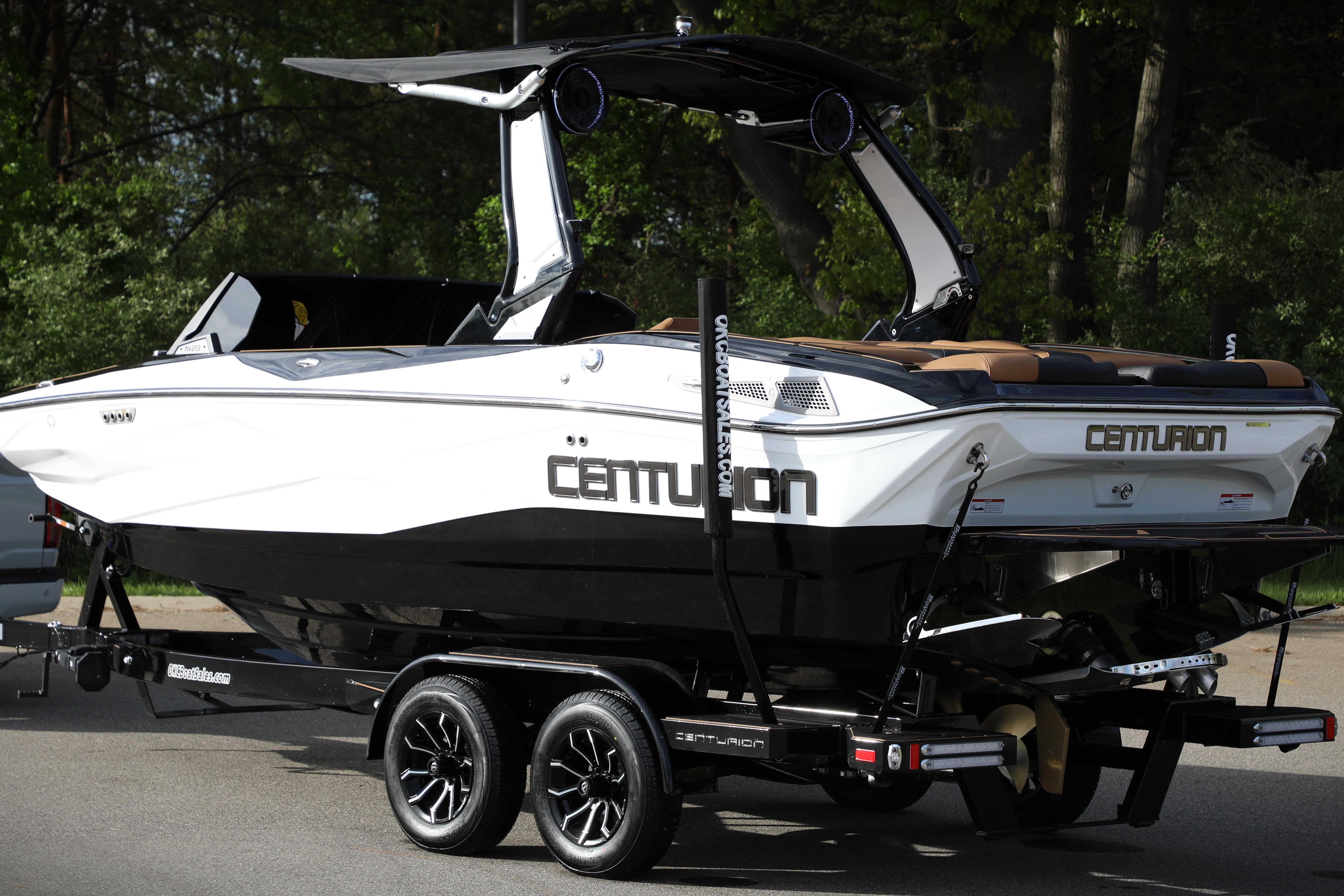 2025 Centurion Nv213 boat on trailer, sleek design, black and white color scheme.