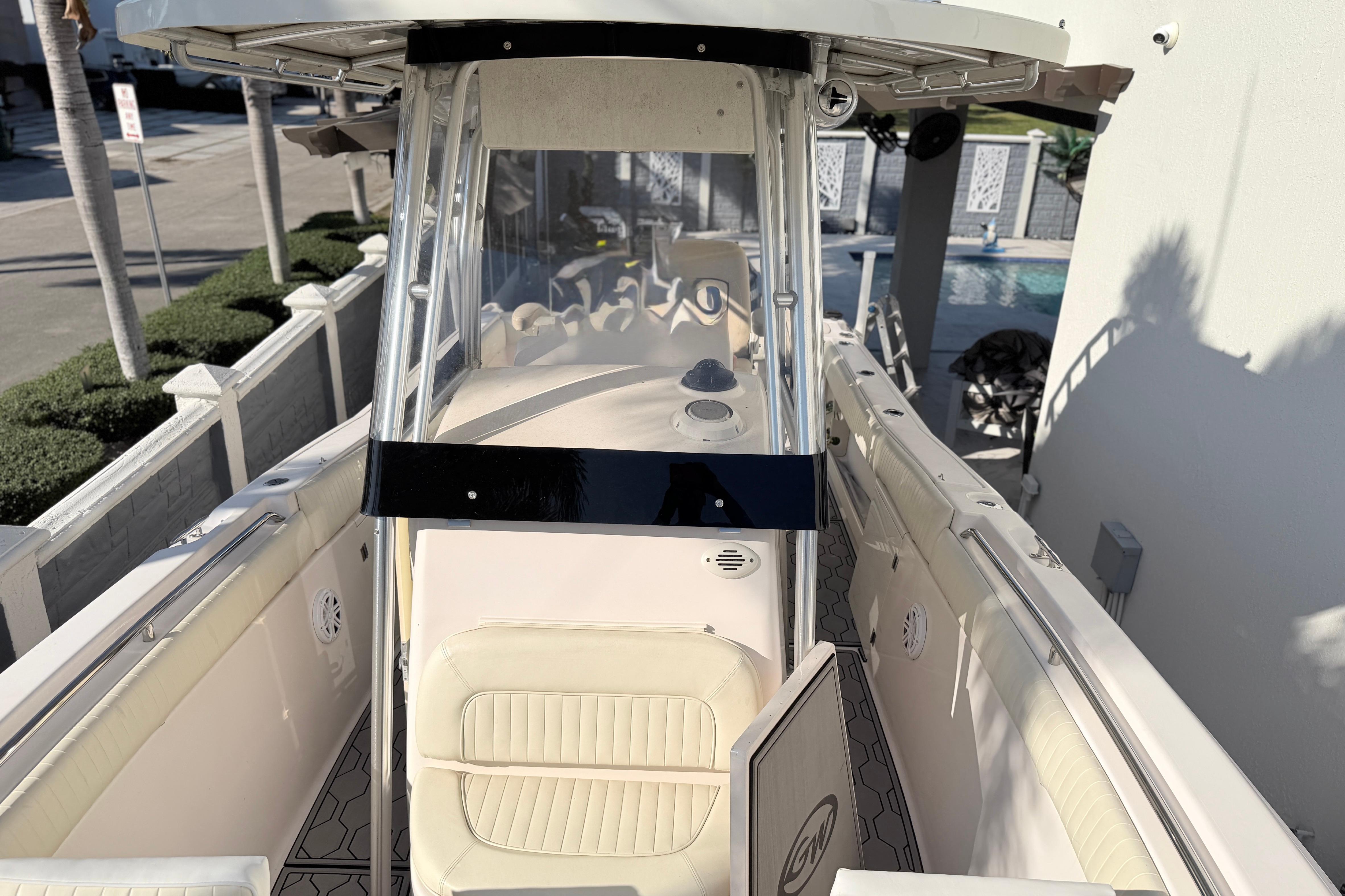 2004 Grady White 273 boat interior with seating and console, docked near a pool.