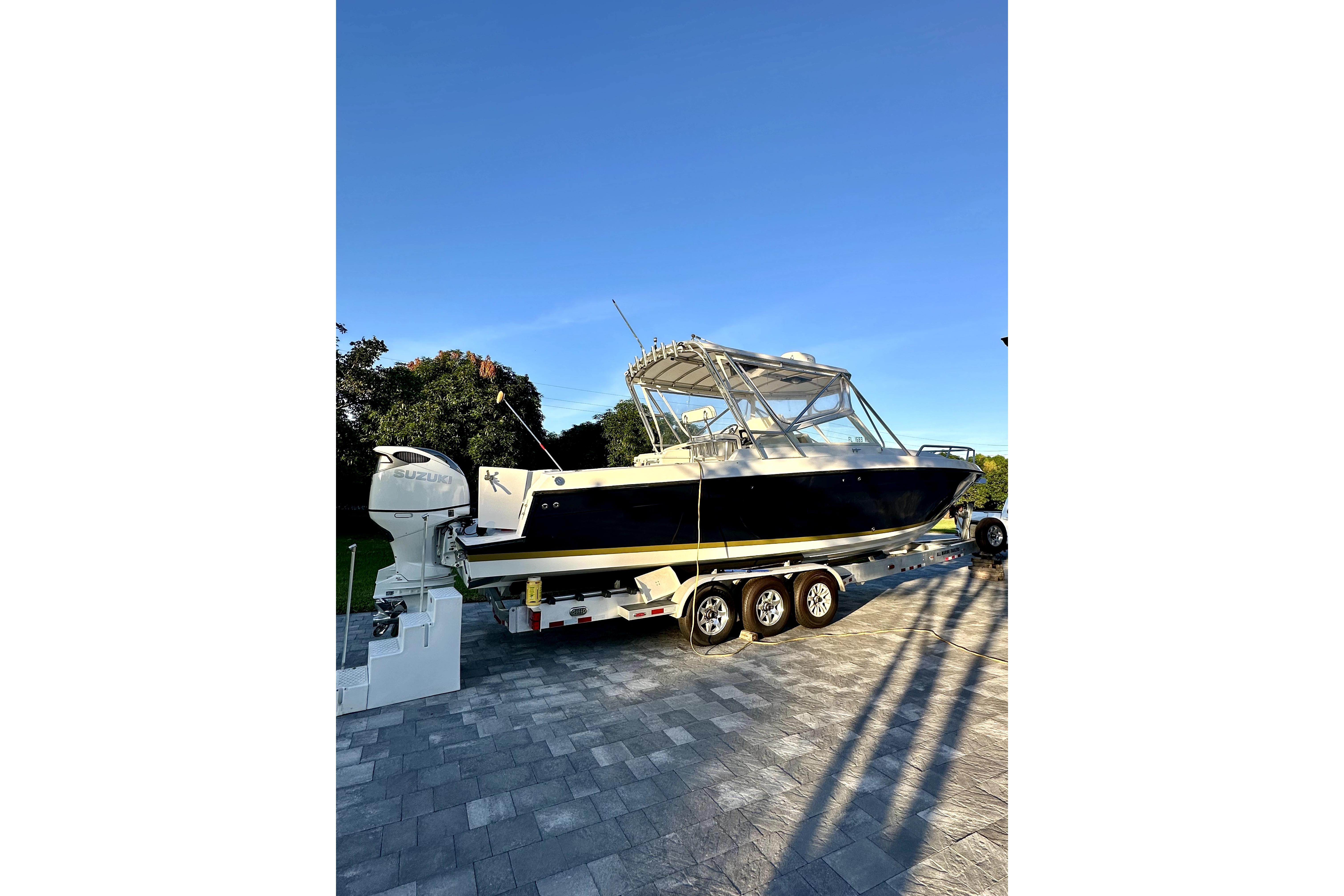 2006 Contender 35 Express Side Console boat on trailer, parked outdoors.