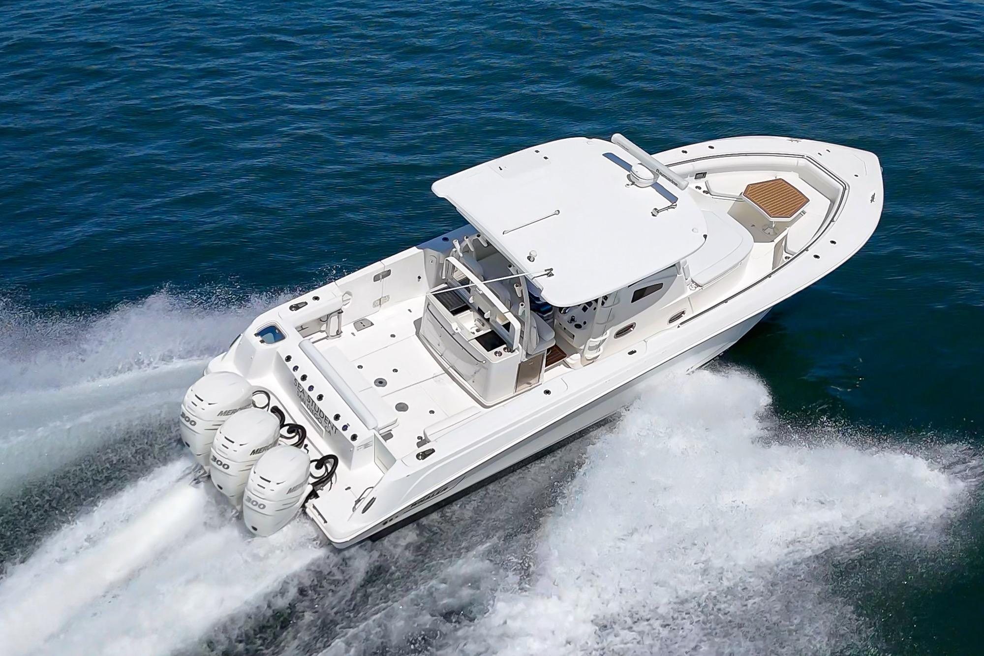 2015 Boston Whaler 370 Outrage speeding on open water, showcasing powerful triple engines.