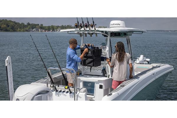 Manufacturer Provided Image: 2026 Hurricane Center Console 24 OB boat on water, two people preparing fishing gear.
