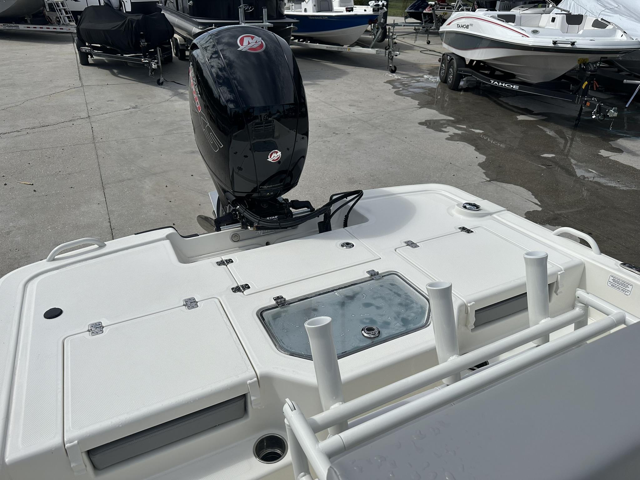 2024 Mako Pro Skiff 19 CC boat with outboard motor, docked on concrete surface.