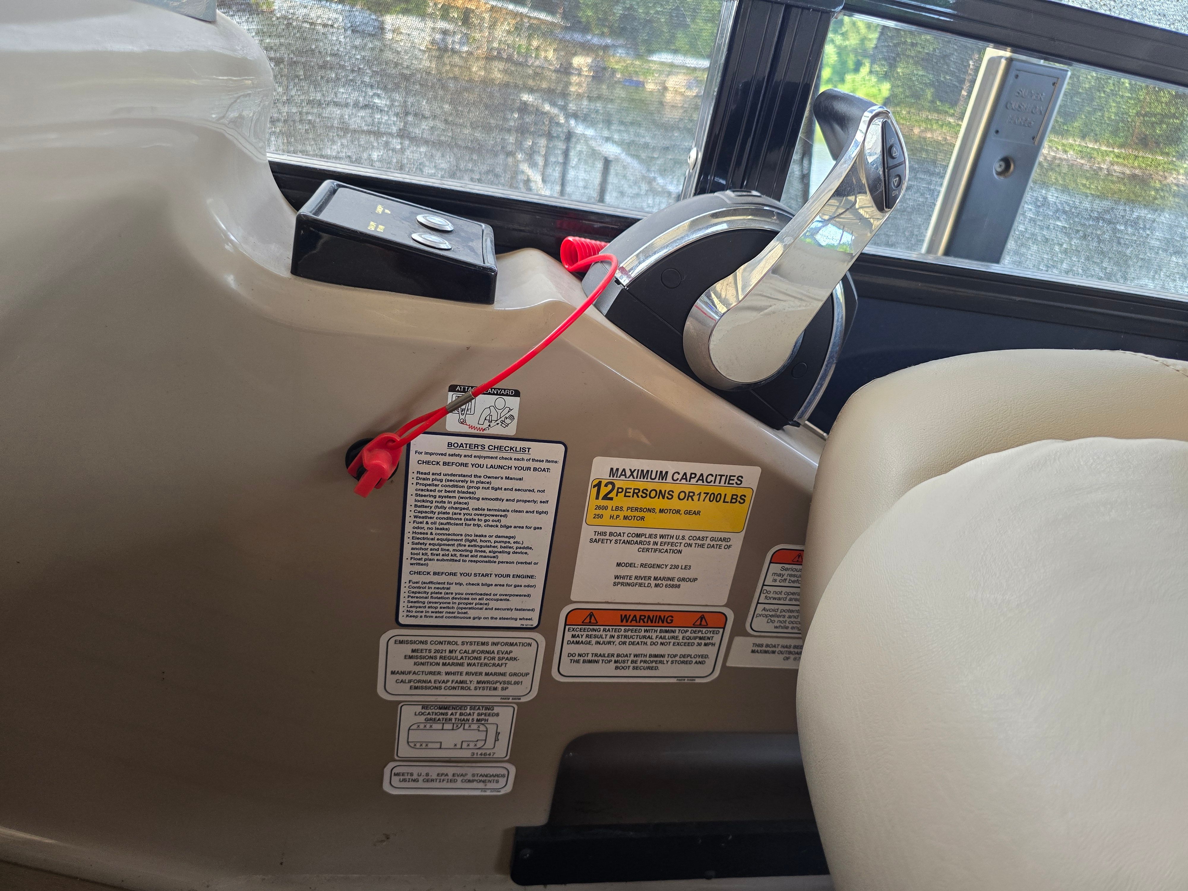 Close-up of the helm of a 2021 Regency 230 LE3 with safety and capacity notices.