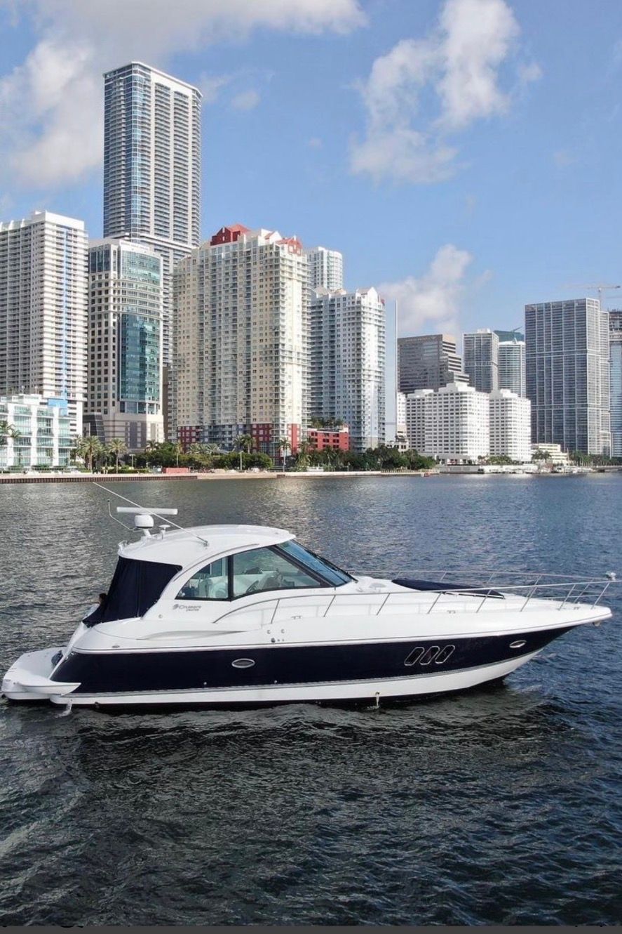 2012 Cruisers Yachts 430 Sports Coupe against city skyline.