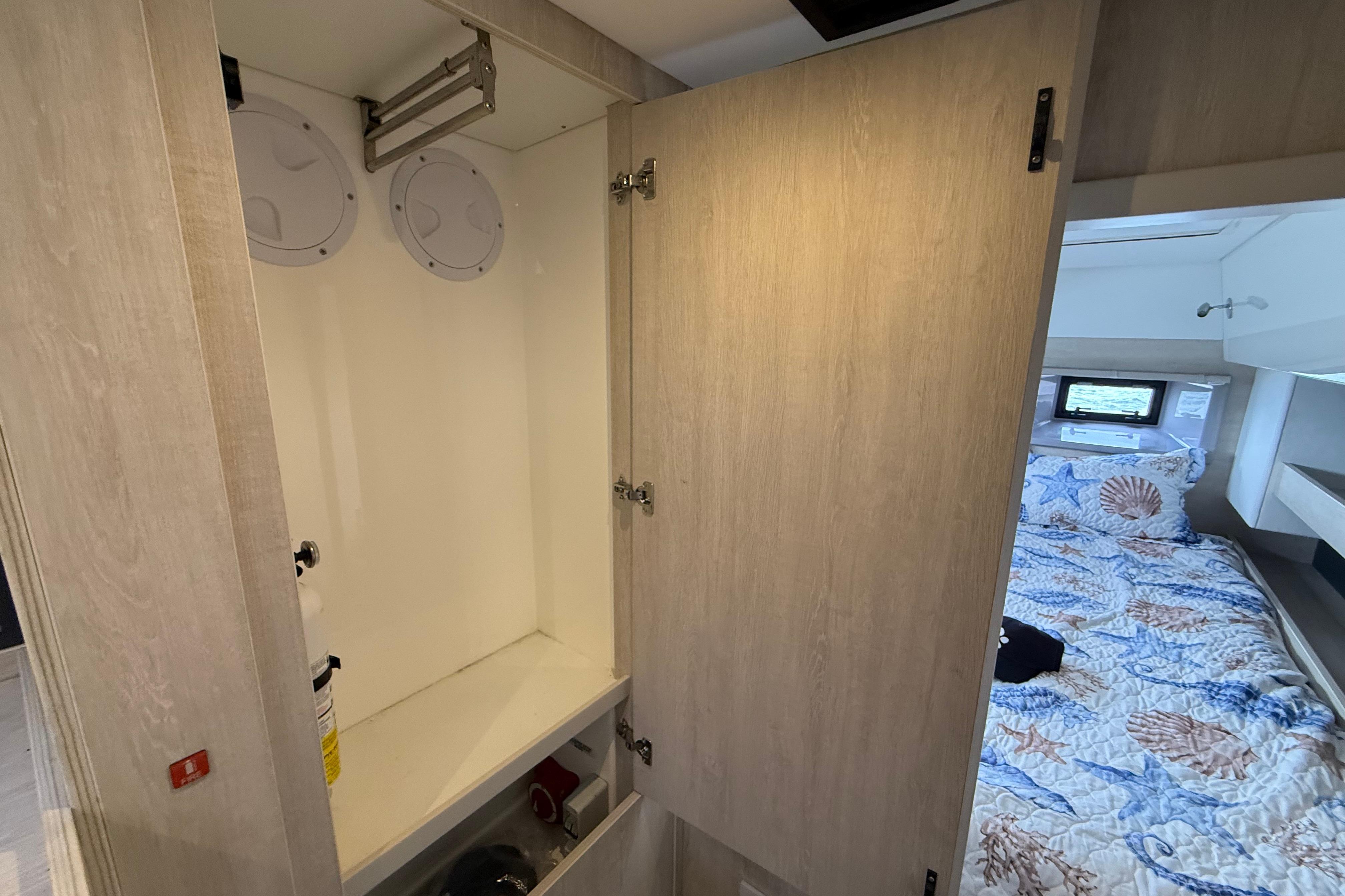 Interior of 2021 Leopard 43 Powercat showing open cabinet and cozy bedroom.