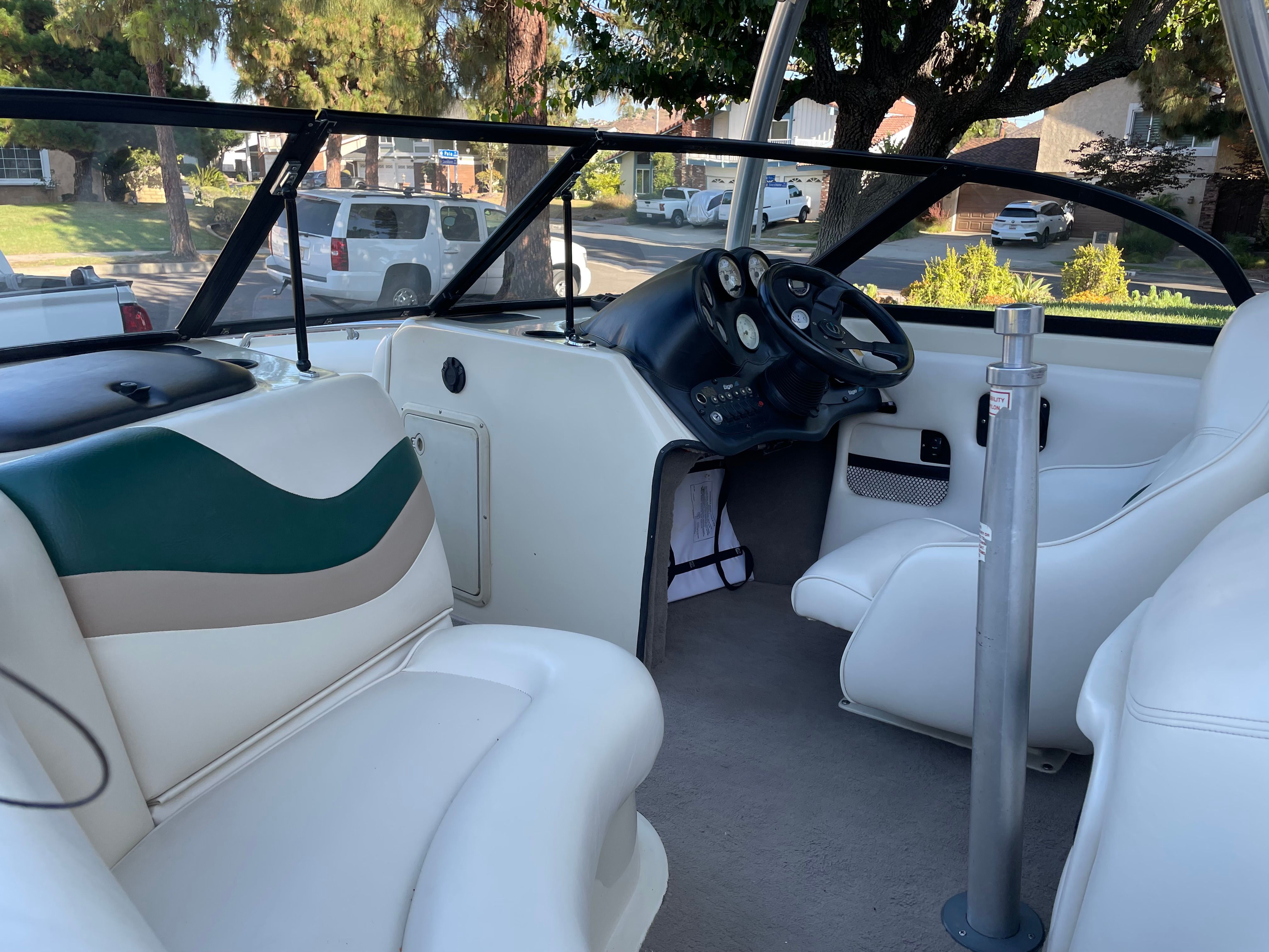 Interior view of a 1998 Tigé Pre 2100 with white seats and a black dashboard.