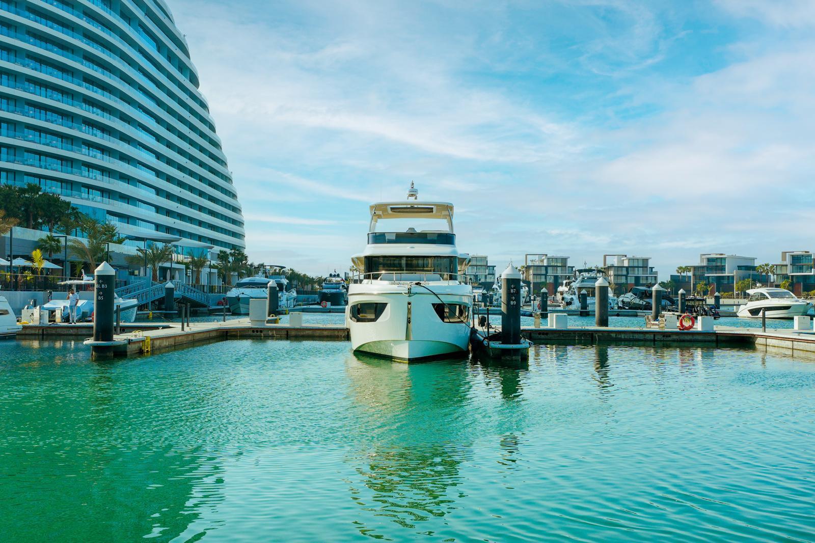 2024 Absolute NAVETTA 52 yacht docked in a modern marina with clear blue skies.